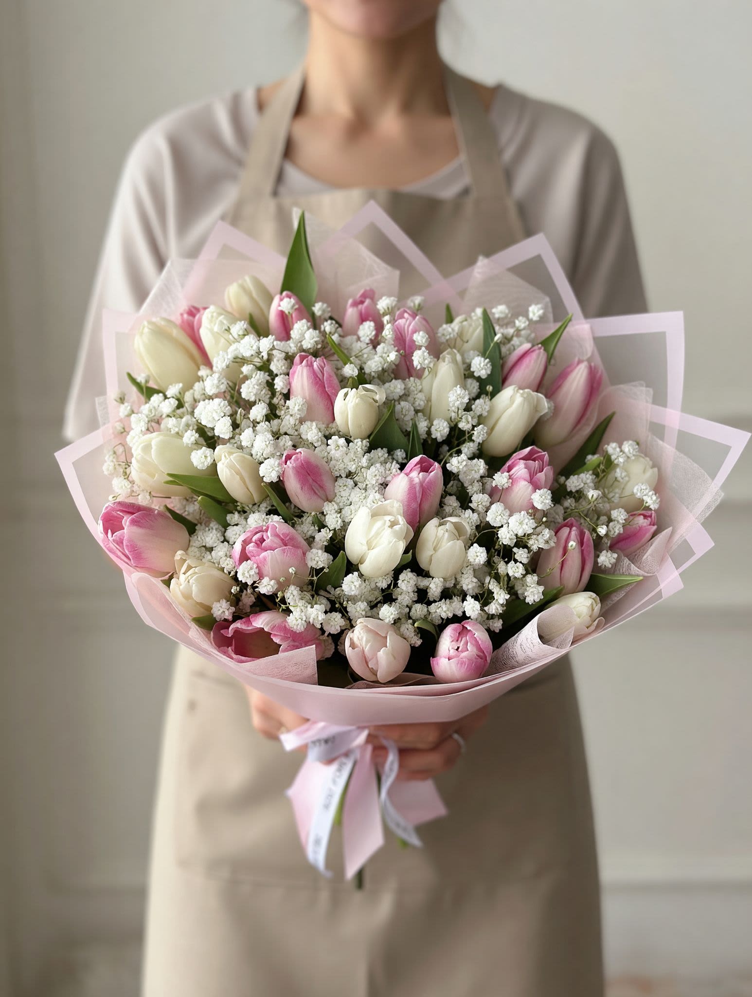 Pink &amp; White Tulip Bouquet (30 Tulips) - Delicate, fresh, and effortlessly elegant — our Blush Tulip Garden Bouquet is the perfect expression of love and appreciation.  This beautifully handcrafted arrangement features a soft mix of blush pink and ivory tulips, complemented by airy baby’s breath and lush greenery for a natural, garden-inspired look. Wrapped in layered blush-toned paper and finished with a satin ribbon, this bouquet embodies simplicity and grace.  Perfect for Mother’s Day, birthdays, or just because, this design offers a light and romantic feel that brightens any moment. Each bouquet is made fresh to order using premium seasonal blooms.  Please note: Tulips may arrive slightly closed and will naturally open beautifully within 1–2 days.