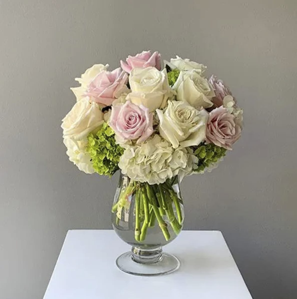 Grace - Capture the essence of elegance and beauty with this stunning rose and hydrangea bouquet. Pink roses, white roses and green mini hydrangea are simply brought together to create a sweet and stylish flower arrangement your special recipient will love.