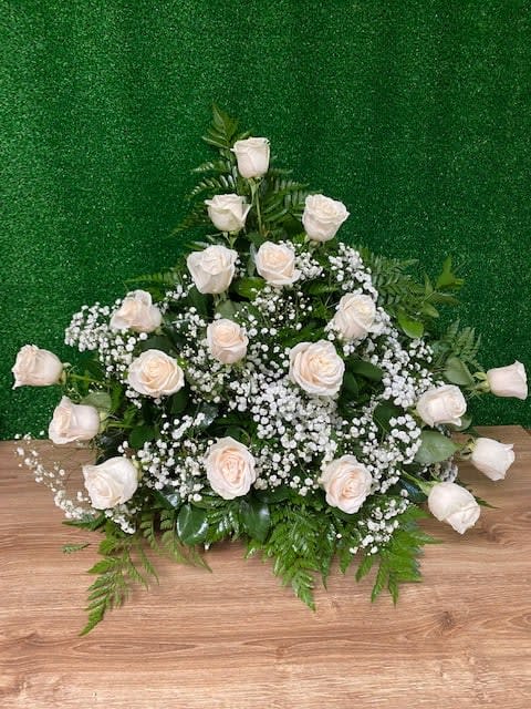 White rose arrangement with baby's breath on a green backdrop