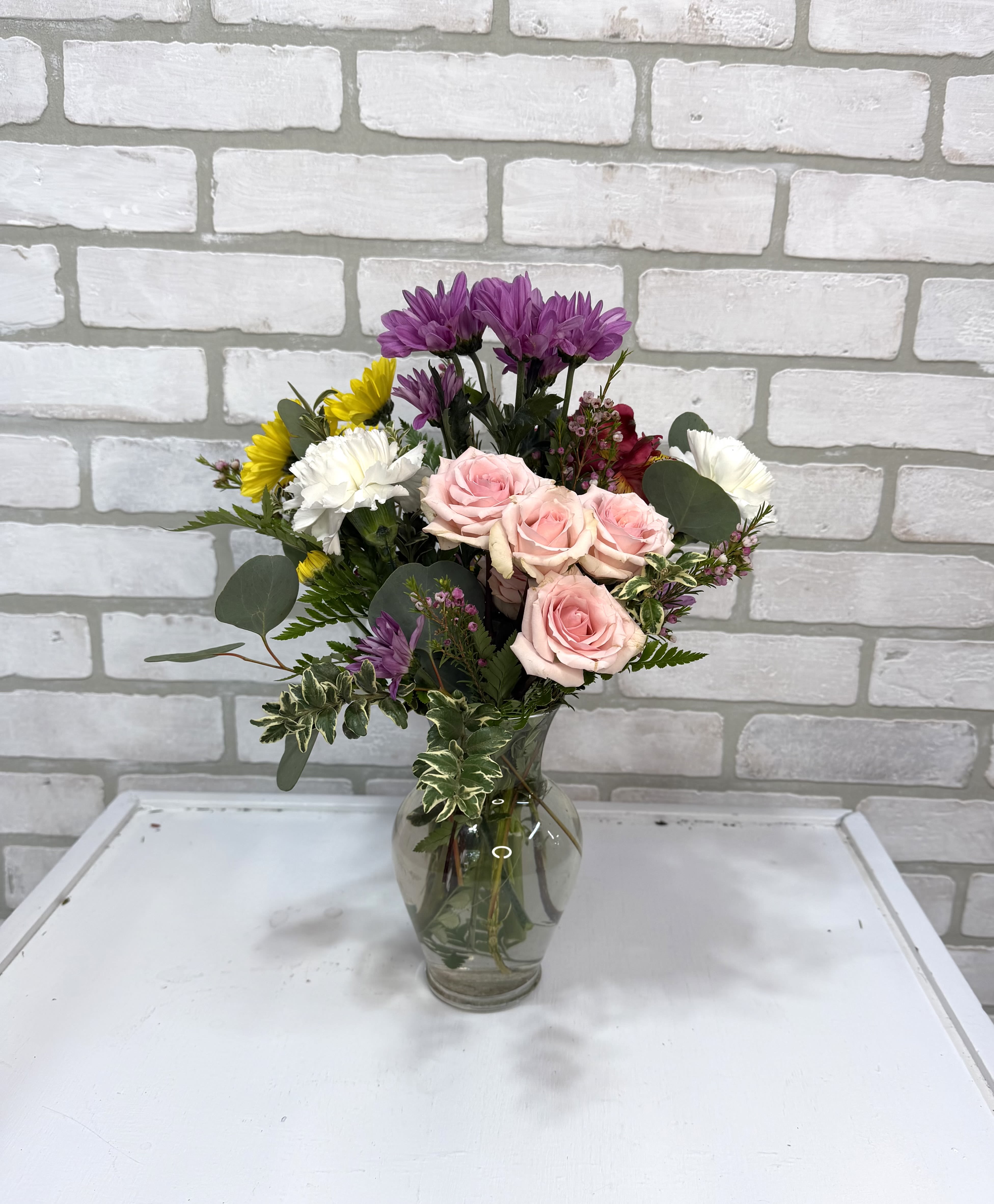 Simply Mom - A clear vase arranged with daisies, alstroemeria lilies, carnations, and spray roses. 