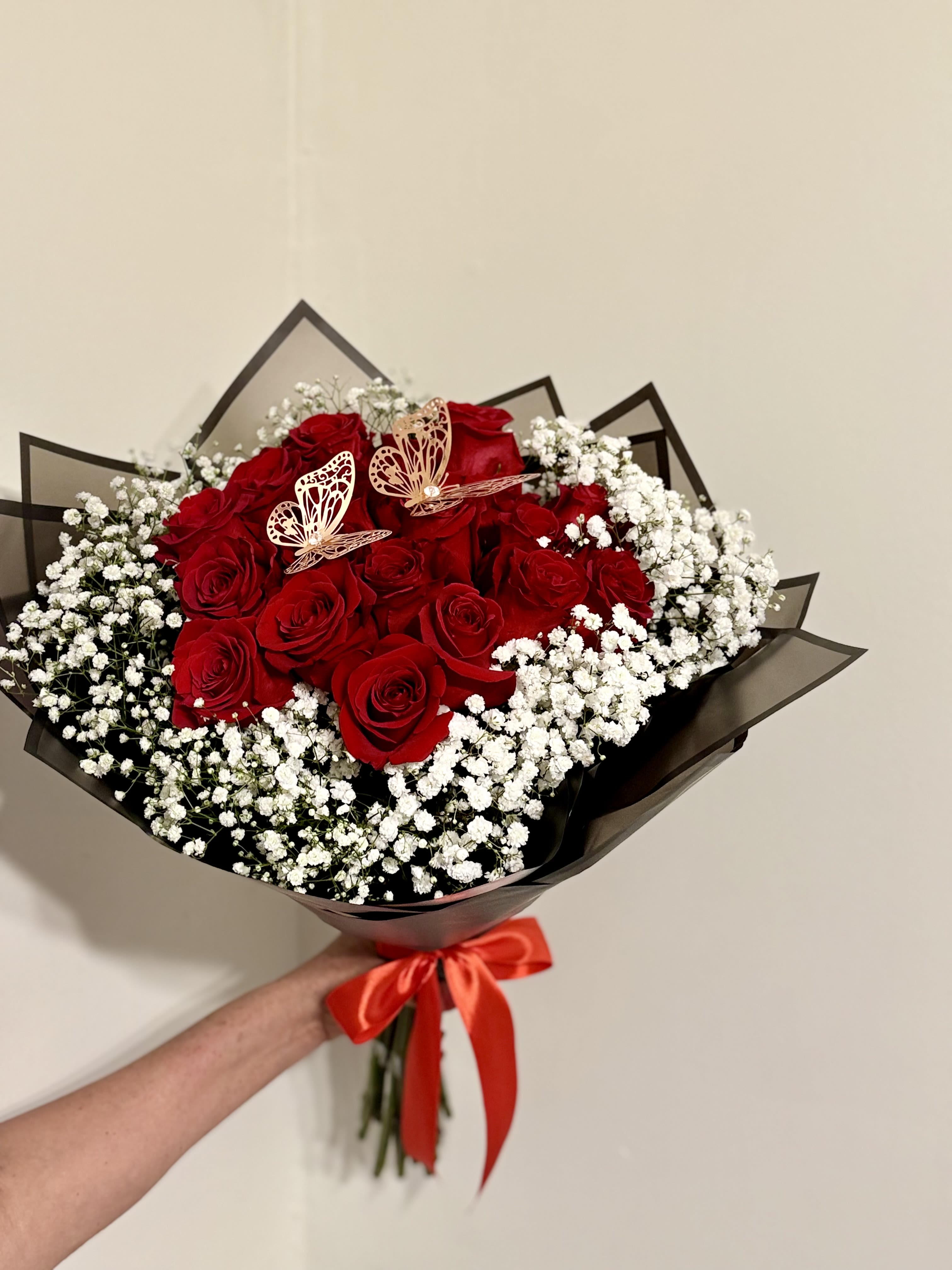 Bouquet of red roses with white baby's breath and a red ribbon