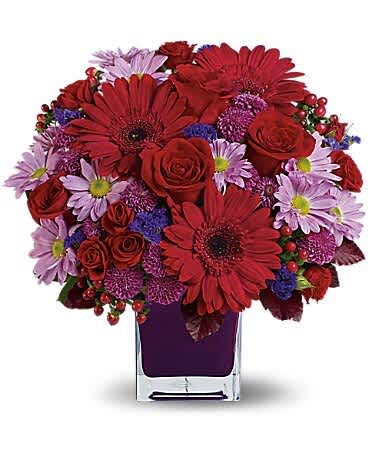 Red and lavender mixed bouquet in a clear square vase