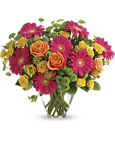 Bouquet of pink gerbera daisies and orange-yellow roses in a clear glass vase