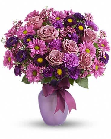 Pink and purple bouquet of roses and daisies in a lavender vase
