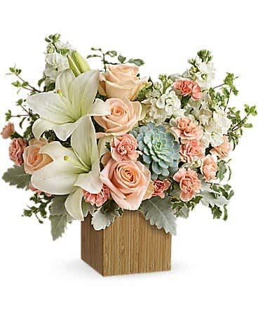 Peach roses and white lilies arranged in a wooden box with succulents