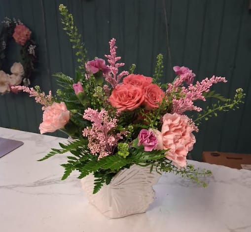 Winged Beauty - Winged Beauty is a graceful Mother’s Day arrangement designed in a charming ceramic butterfly container. Overflowing with lush greens and a gathering of hardy, long-lasting blooms, this piece captures the beauty of spring and the gentle love of a mother. A whimsical keepsake container paired with fresh florals makes this arrangement a heartfelt gift she can enjoy long after Mother’s Day has passed.