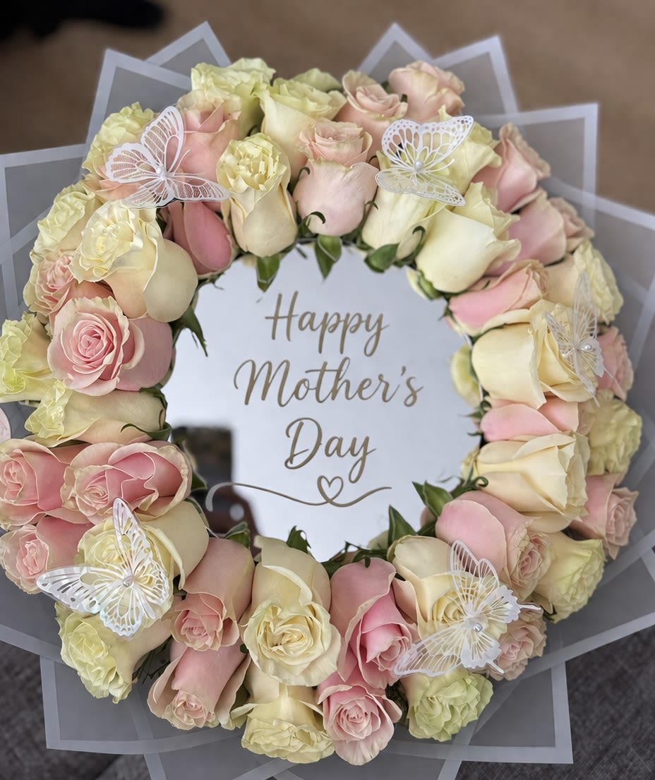 Blush Rose Mirror Bouquet - Elegant circular arrangement of soft pink and ivory roses surrounding a mirrored center with a delicate “Happy Mother’s Day” message. Accented with decorative butterflies, this piece is perfect for gifting and adding a touch of sophistication to any space.