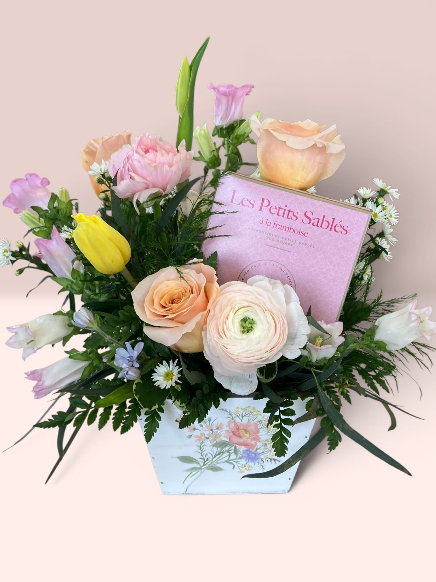 Flowers and Cookies for Mom - Surprise Mom with joy of flowers and a delicious treat of cookies. Designed in a wooden box this bouquet include roses, tulips, ranunculus, campanula and a 3.5oz box of French shortbread cookies. This bouquet is sure to make Mom's day! Product size 15x12"