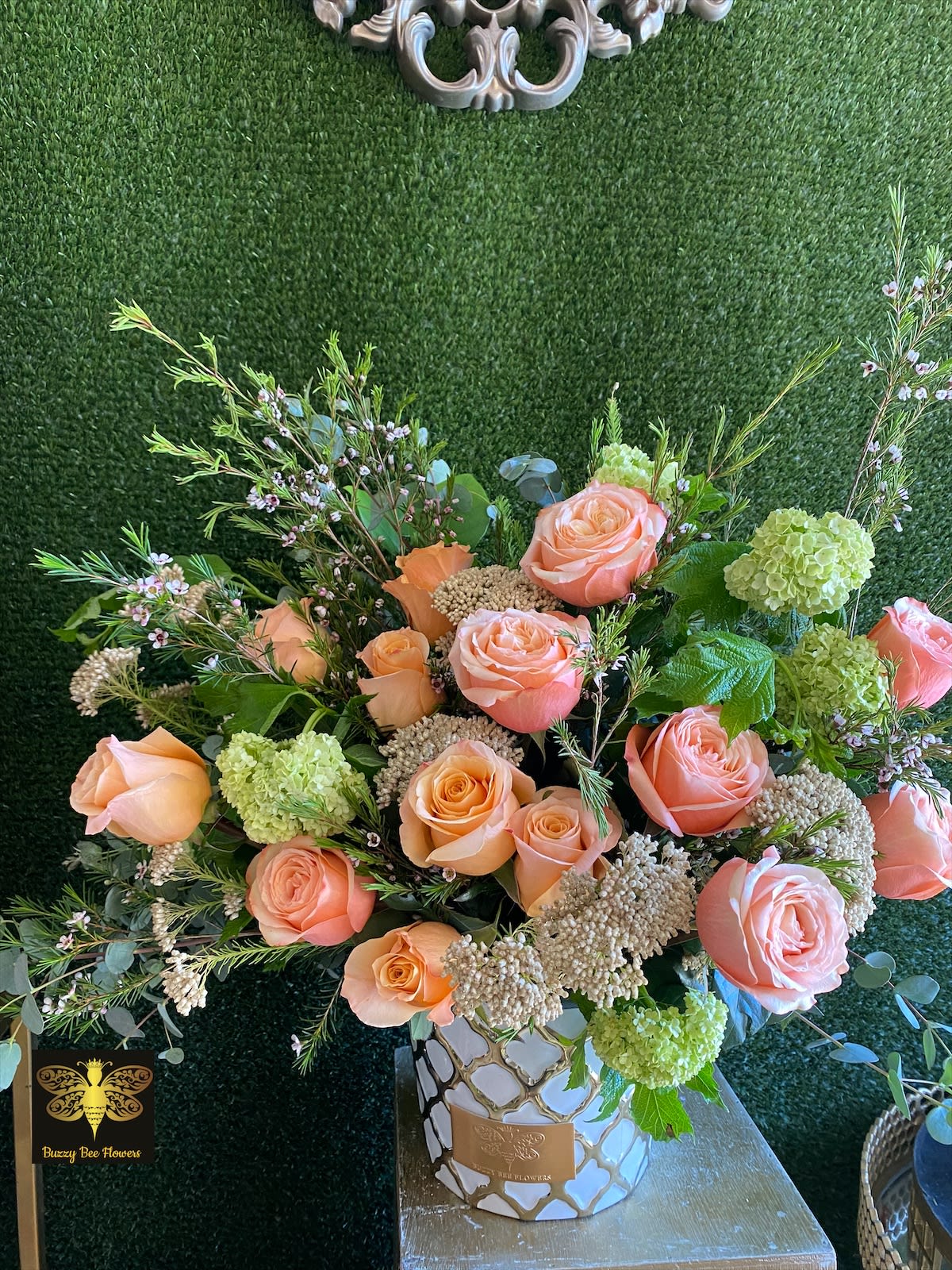 Peach roses and green hydrangeas in a decorative vase