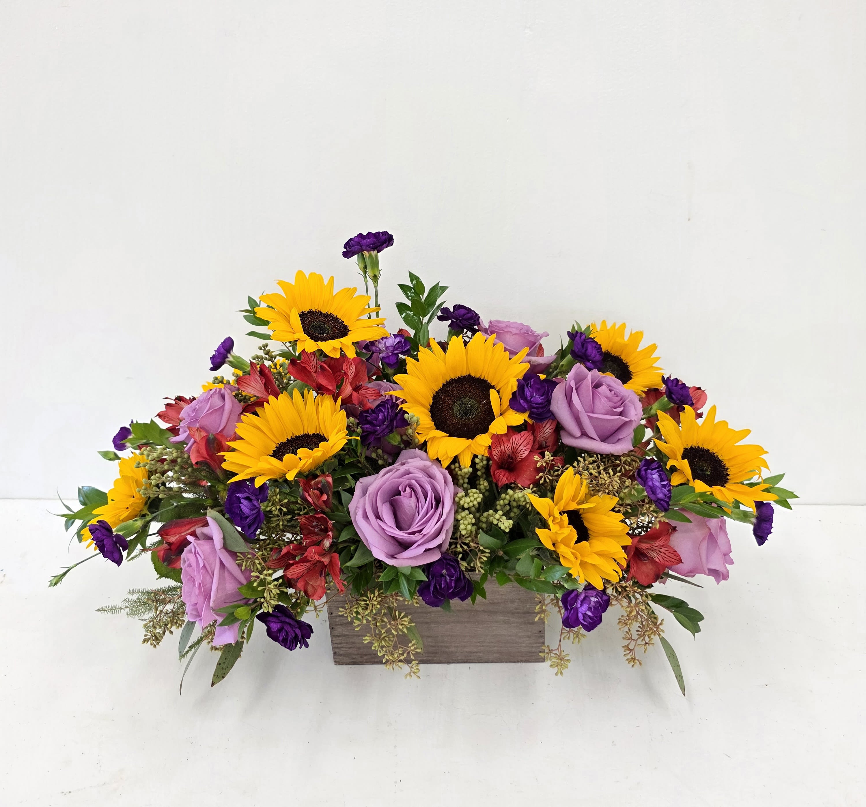 Box of Sunflowers - Bright mixed blooms-sunflowers, roses, alstroemeria and accents arranged full in a low wooden box. AS PICTURED: PREMIUM ONE SIZE ONLY. 12" BY 12"B