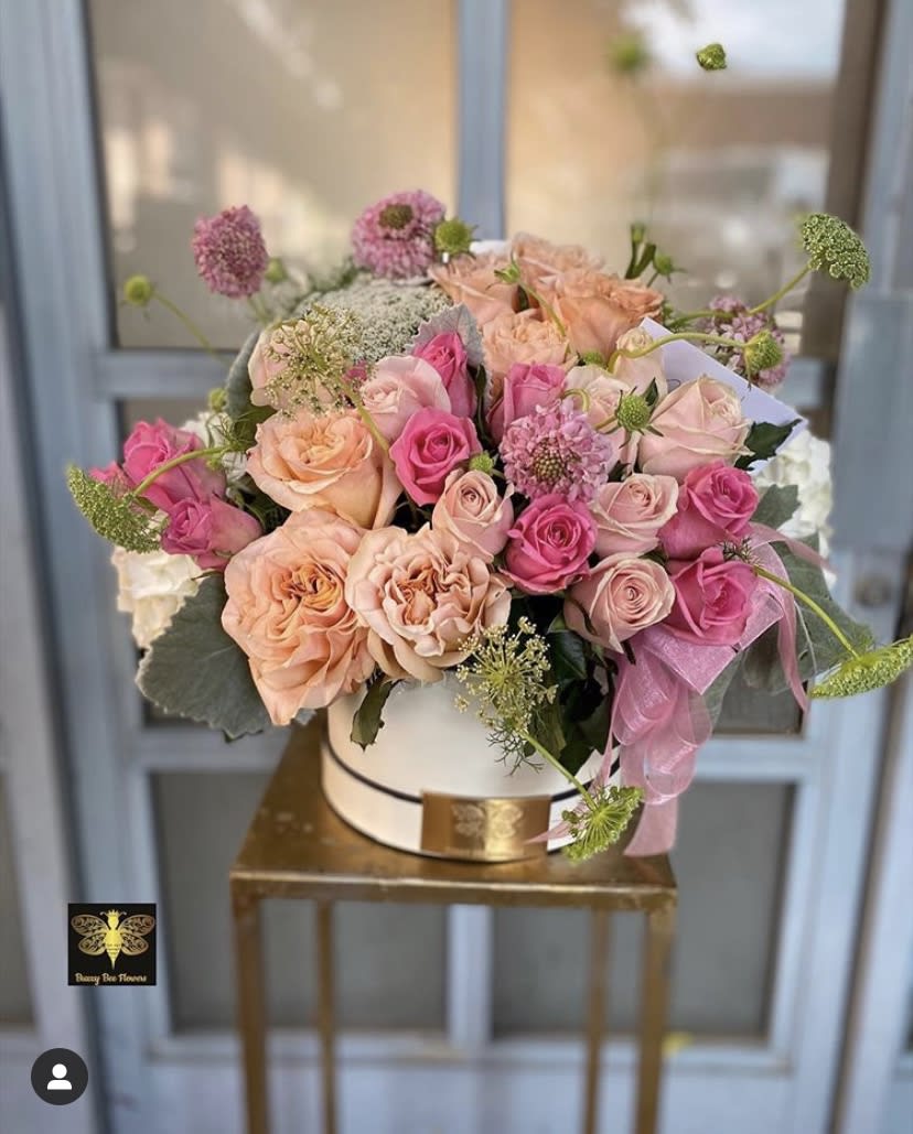 Pink and peach rose bouquet in a white hatbox with a pink ribbon