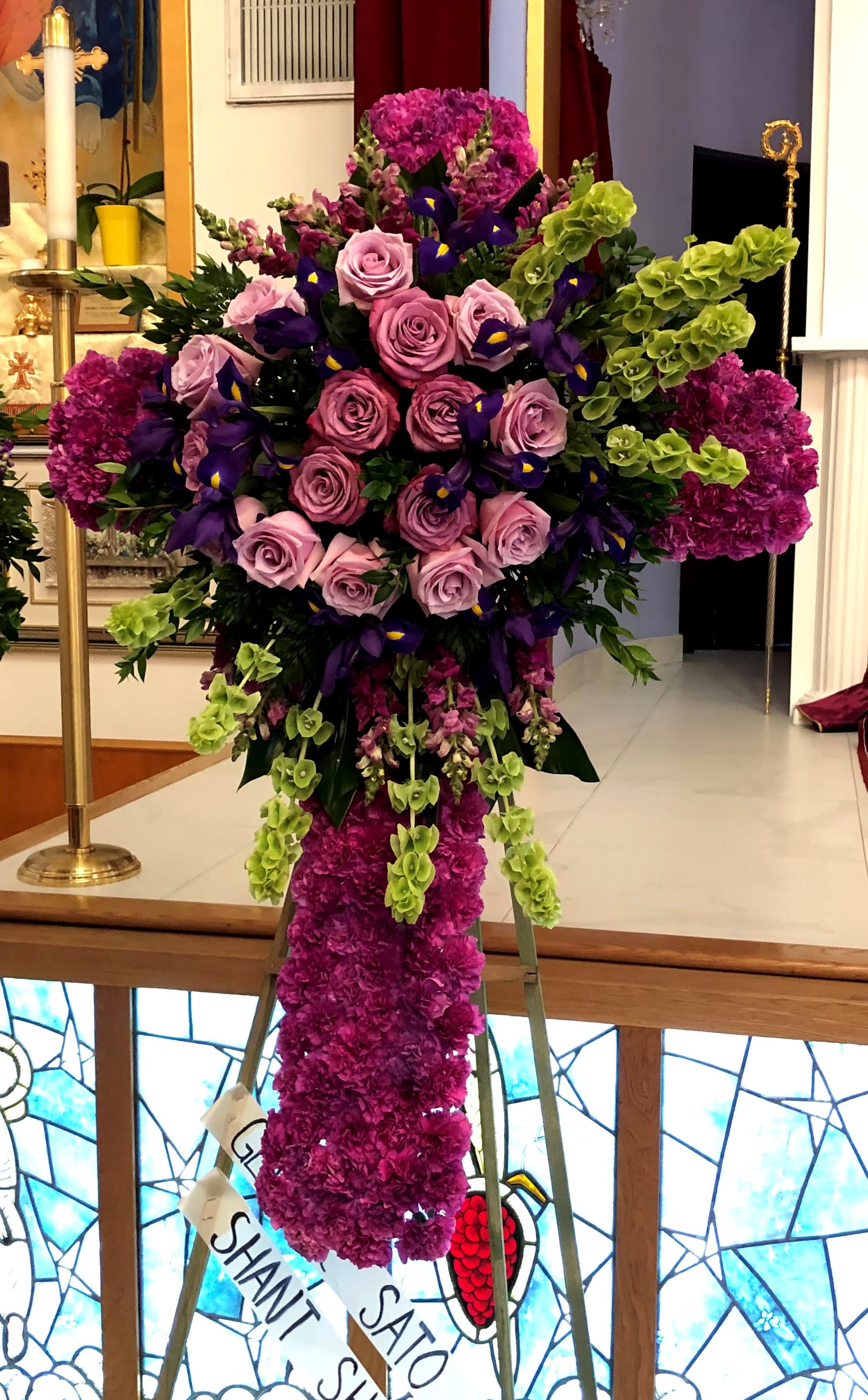 Tall standing floral spray with pink roses, purple flowers, and green accents