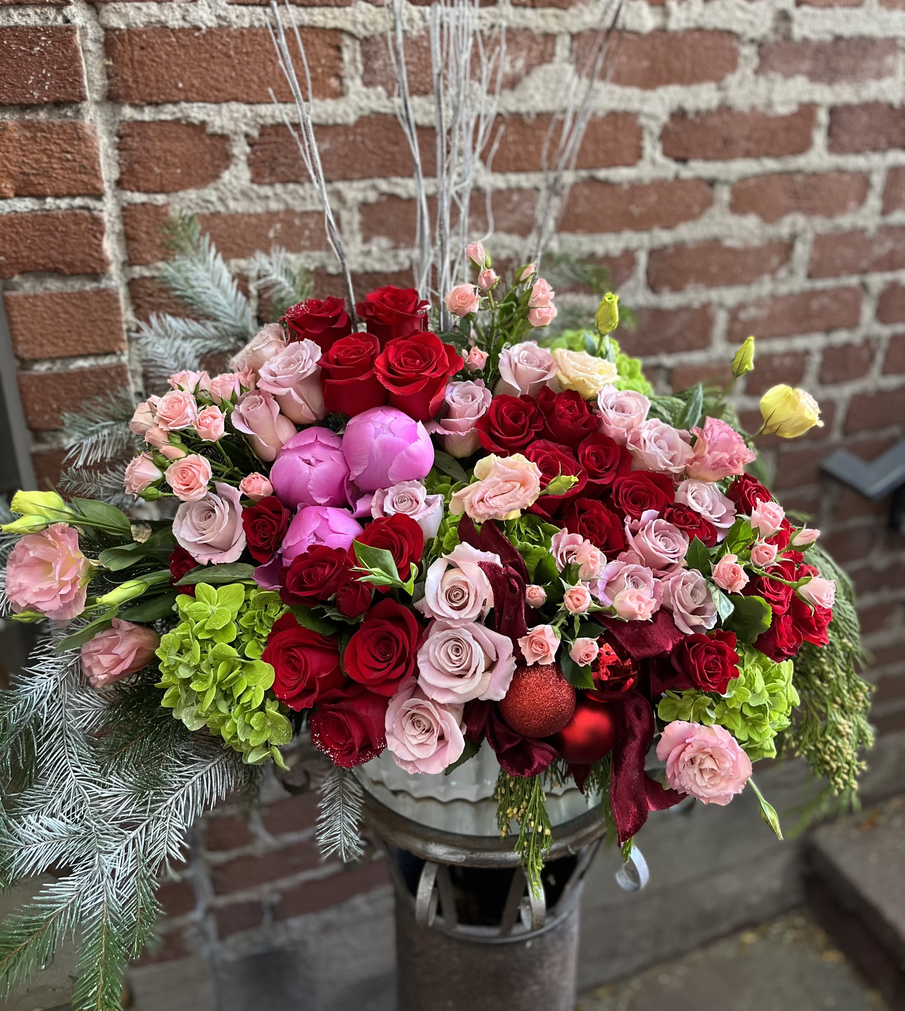 Large bouquet of red and pink roses with ornaments in a vase
