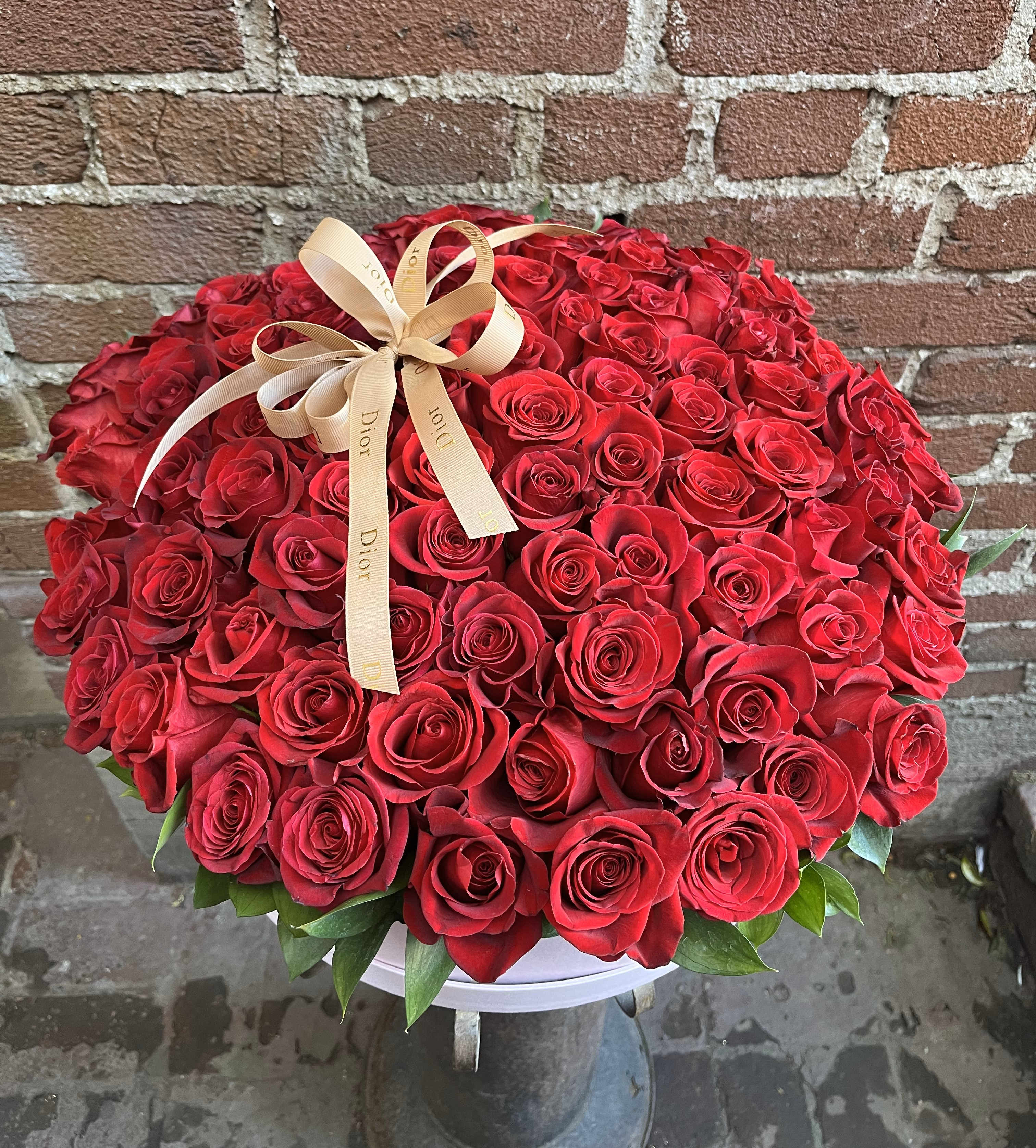 Large bouquet of red roses with a beige ribbon bow