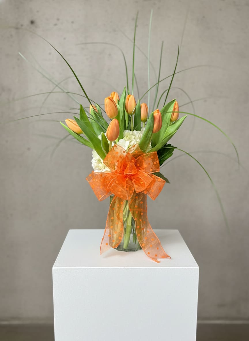 Orange Dream Tulips - Bright and happy are a great way to describe this delightful dream tulip bouquet.  Ten delicate orange Tulips (shade of orange may vary) arranged with hydrangeas and bear grass in a clear glass vase.  Approximately 12" W x 14" H  Orientation: All-Around  Standard: 10 Tulips Deluxe: 20 Tulips Premium: 30 Tulips
