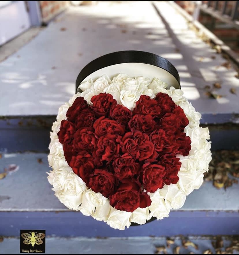 Heart-shaped bouquet of red and white roses in a black box