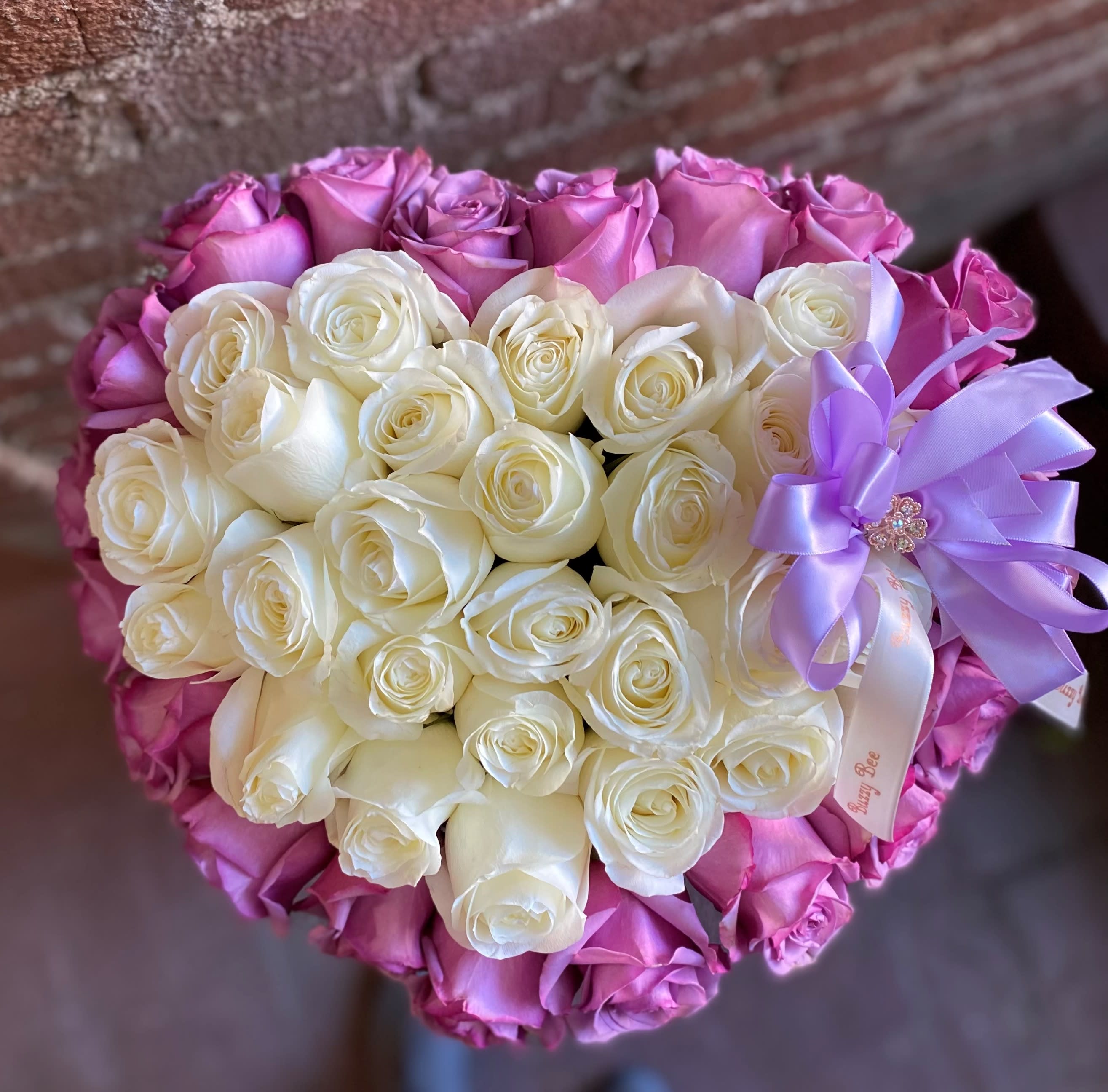 Bouquet of white and pink roses with a lavender ribbon
