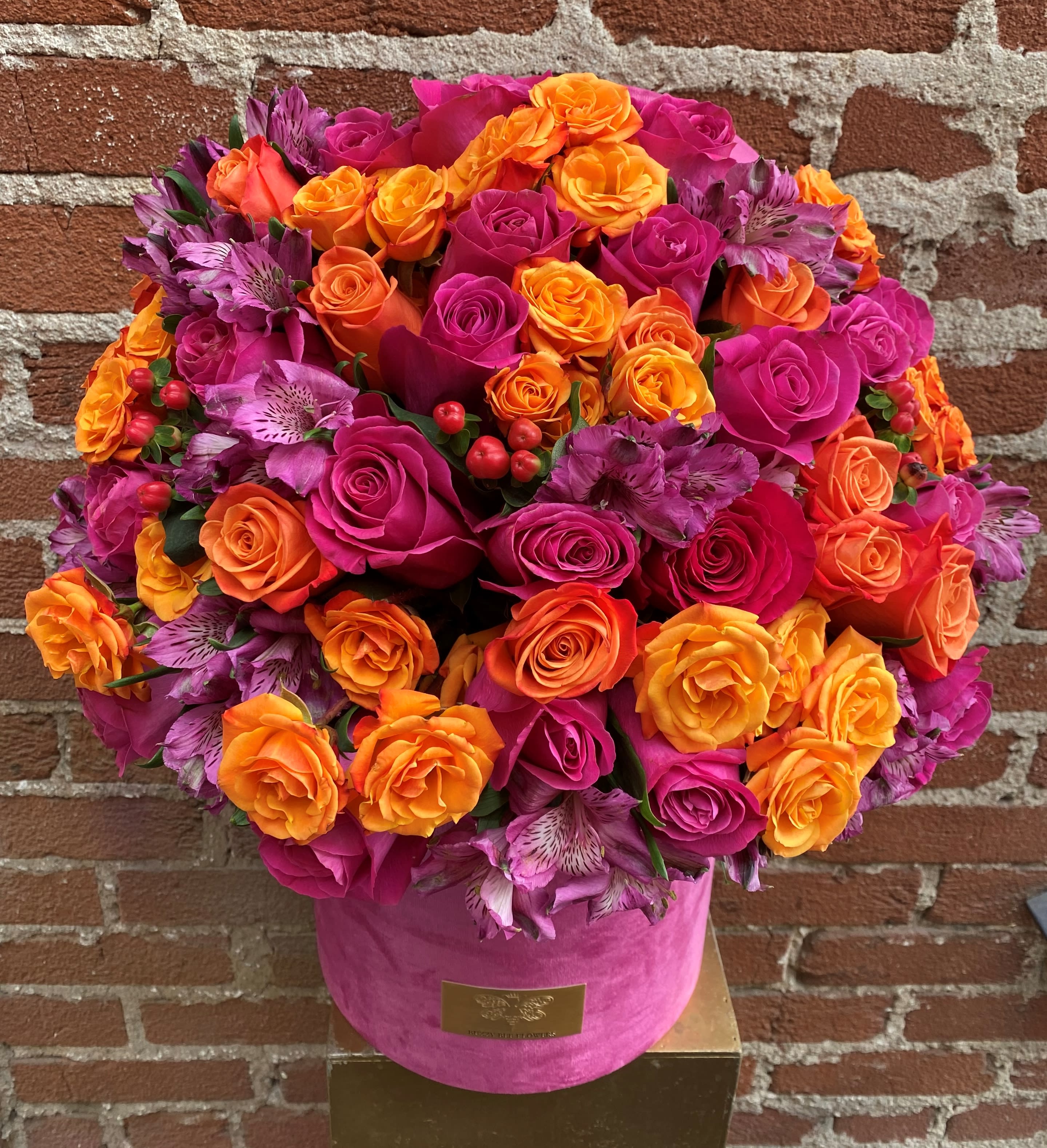Bright pink and orange rose bouquet in a pink hat box