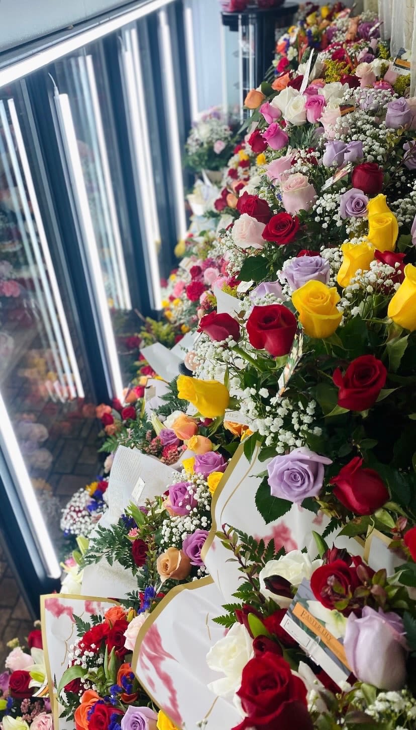 Rows of colorful rose bouquets wrapped in white paper