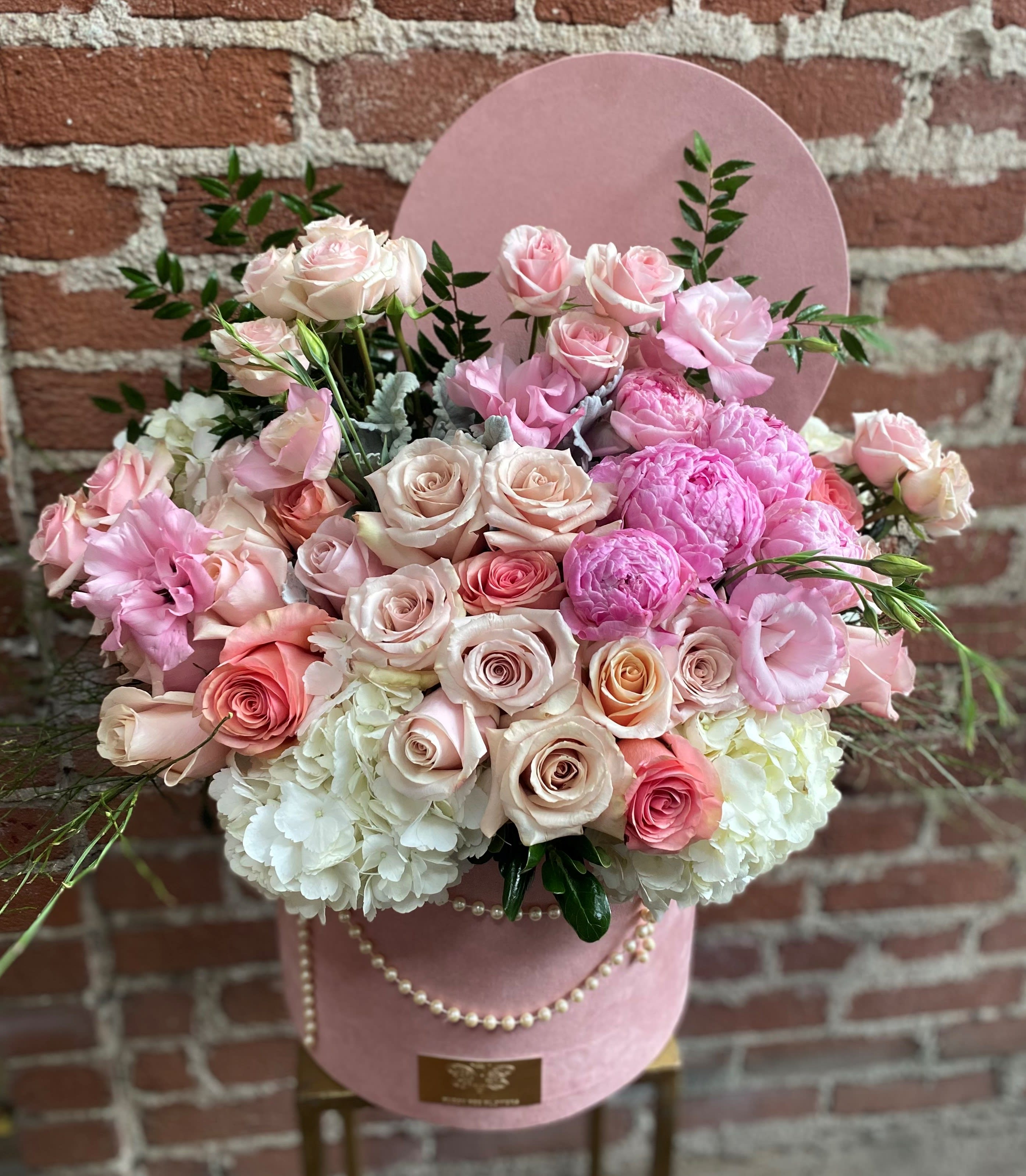 Pink and white rose bouquet in a pink hatbox with pearl trim