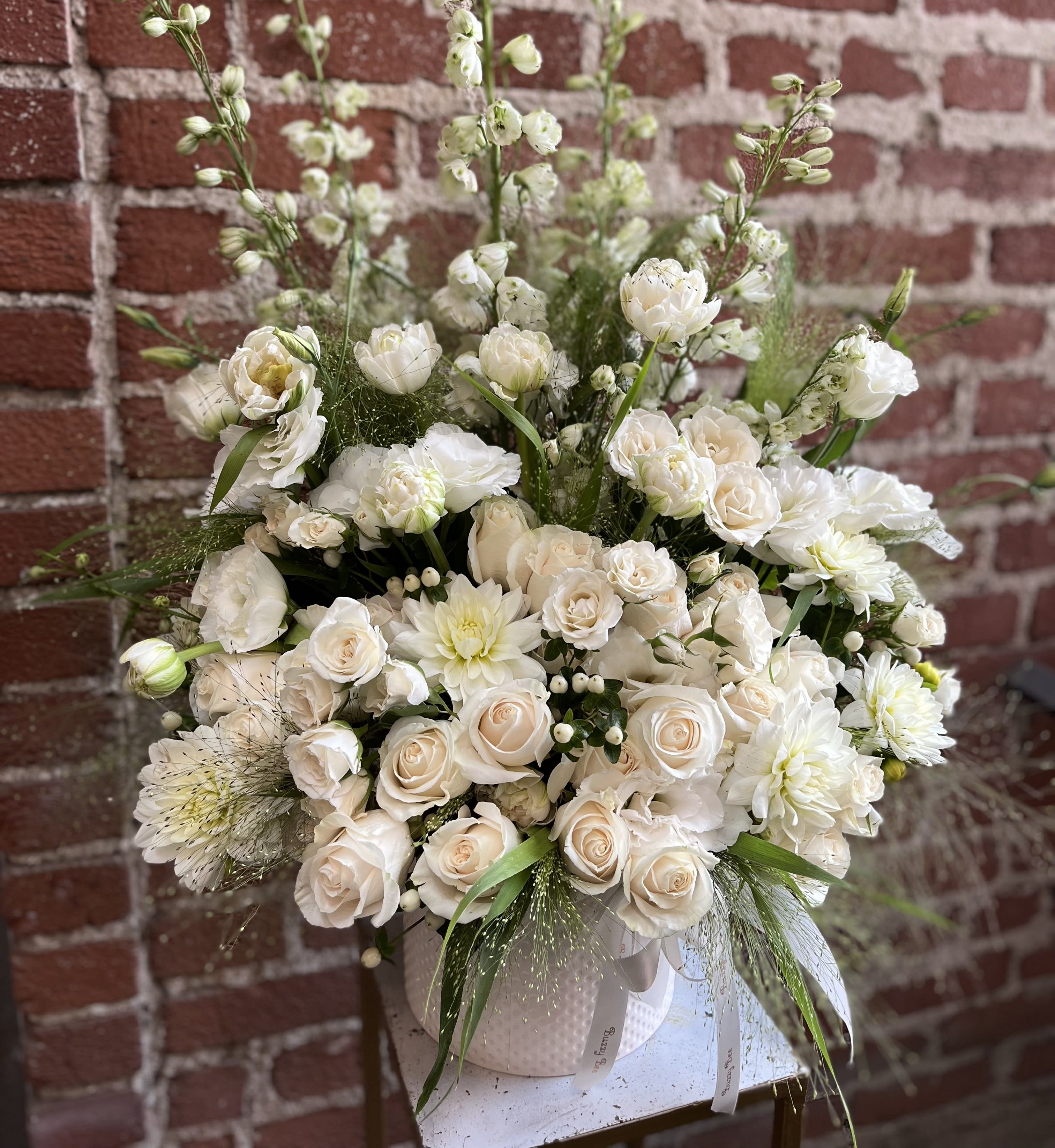 White roses and mixed white blooms arranged in a vase