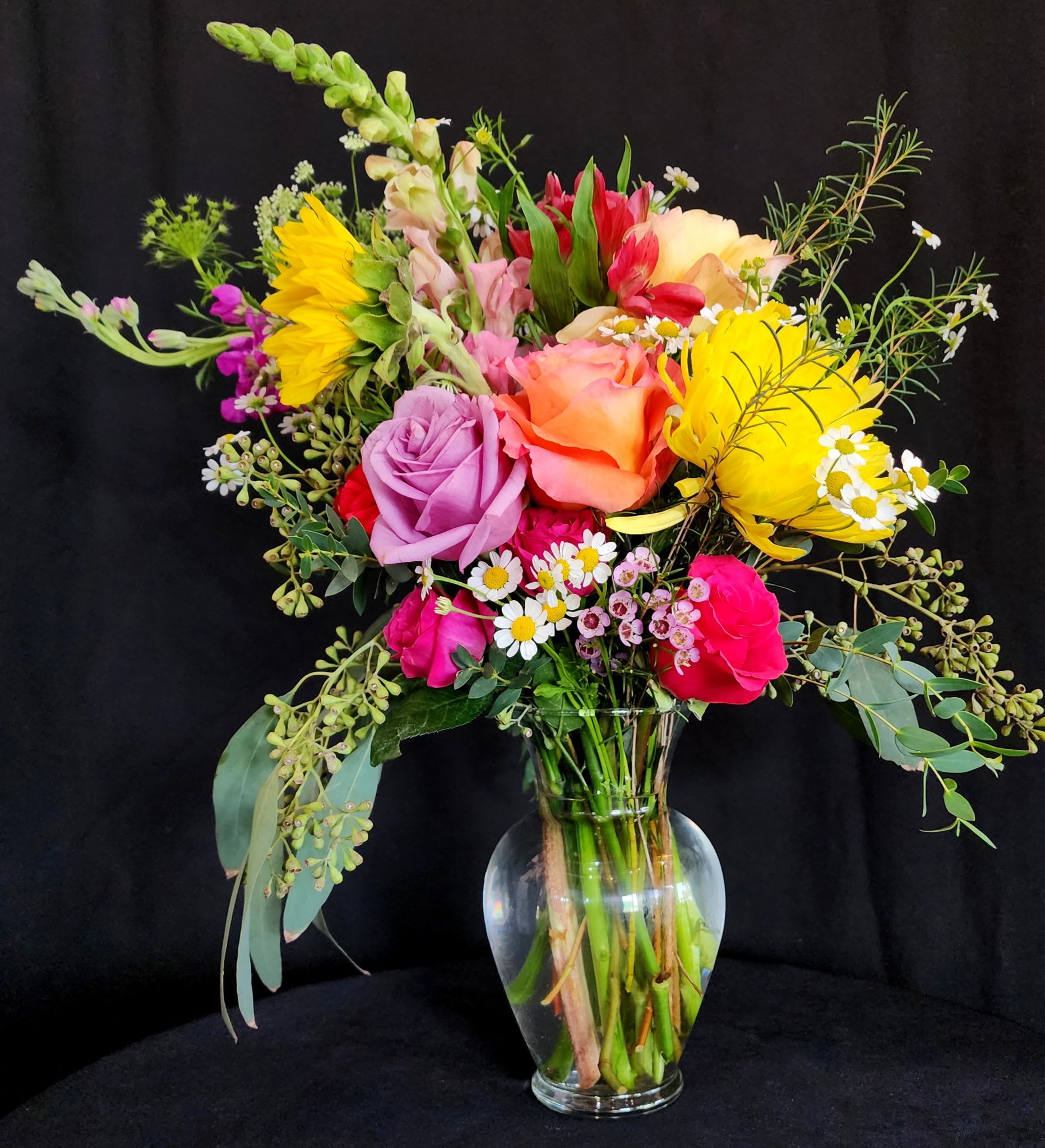 The Mini Bad Ass - Mini version of our signature arrangement, The Bad Ass! This arrangement represents the signature style of Buds Blooms &amp; Bad Asses, displaying the variety of unique flowers with a natural garden look. Perfect for a gift to someone who is a certified BAD ASS!   Dimensions are as follows:  18" Height x 14" Length x 11" Width in an 7 1/2" glass vase.  
