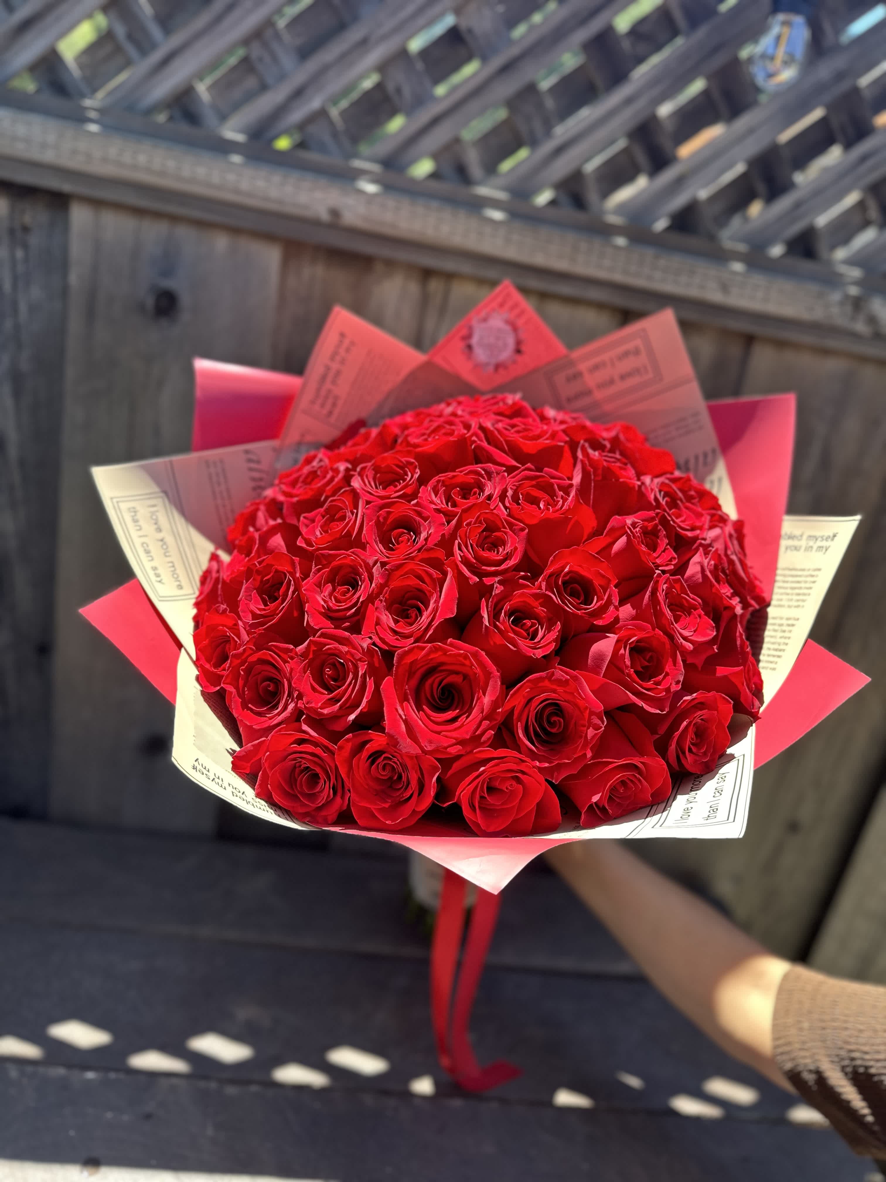 Bouquet of red roses wrapped in pink and cream paper