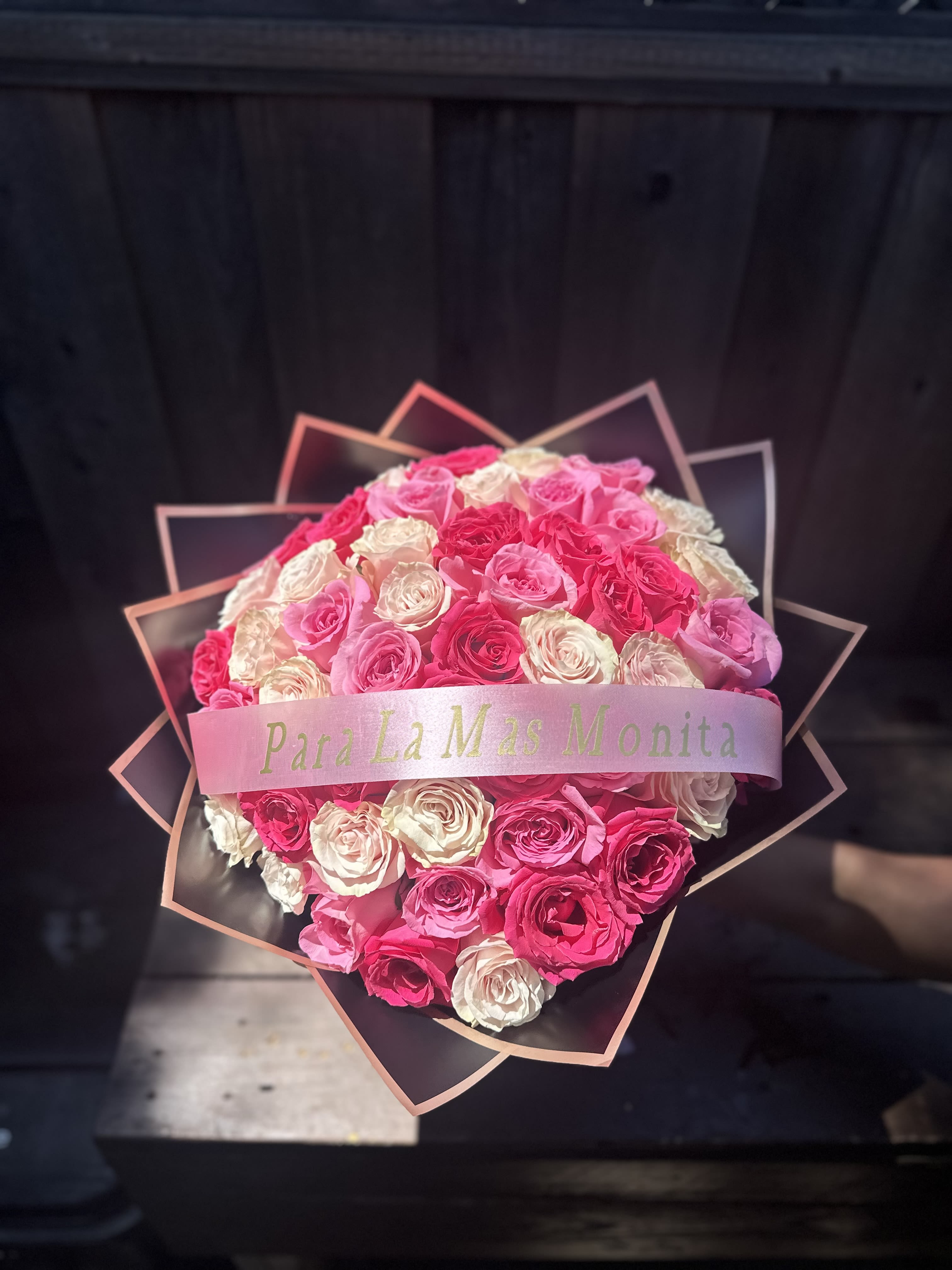 Heart-shaped bouquet of pink and white roses with a ribbon band