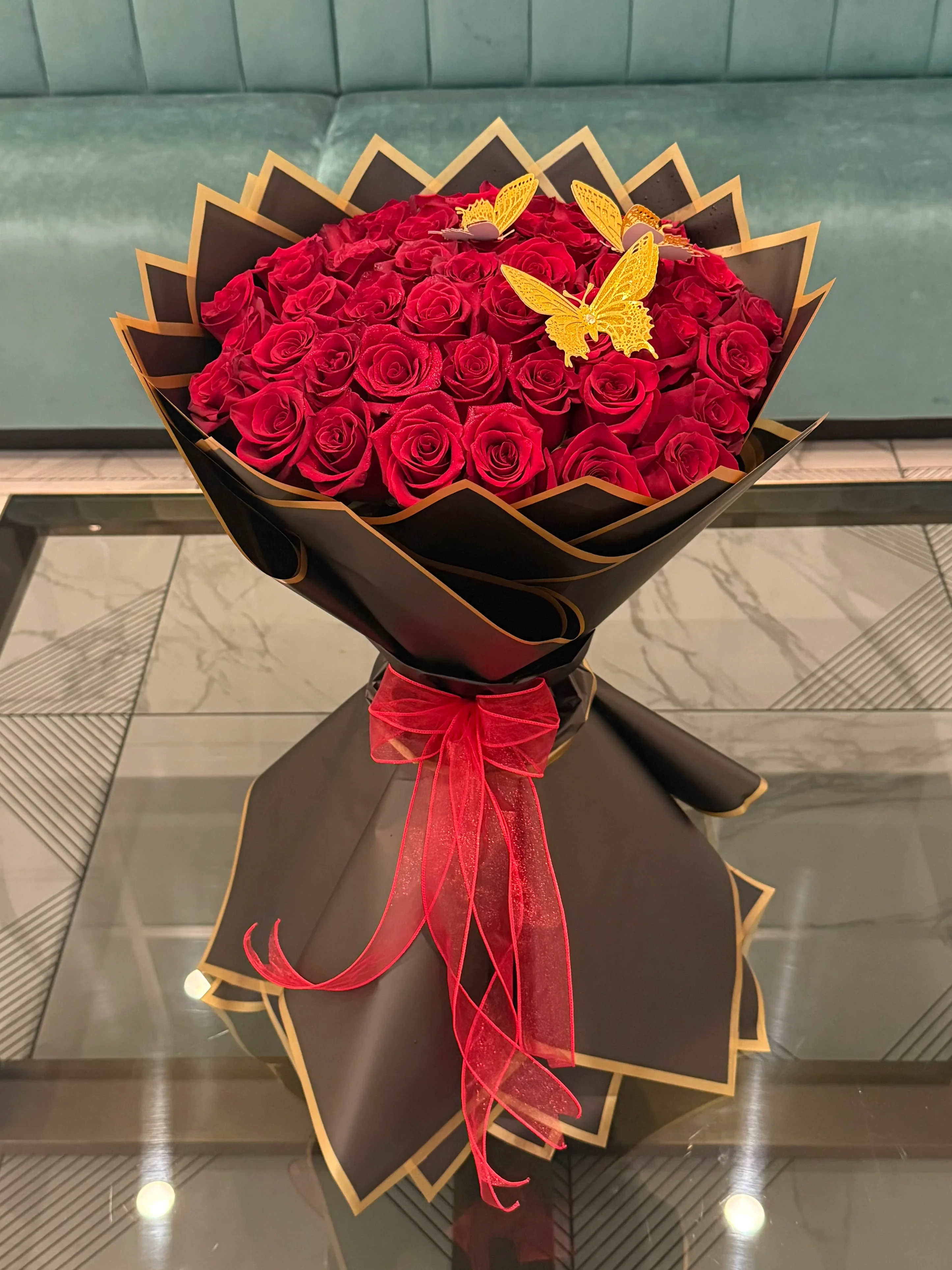 Bouquet of red roses wrapped in black paper with a red ribbon