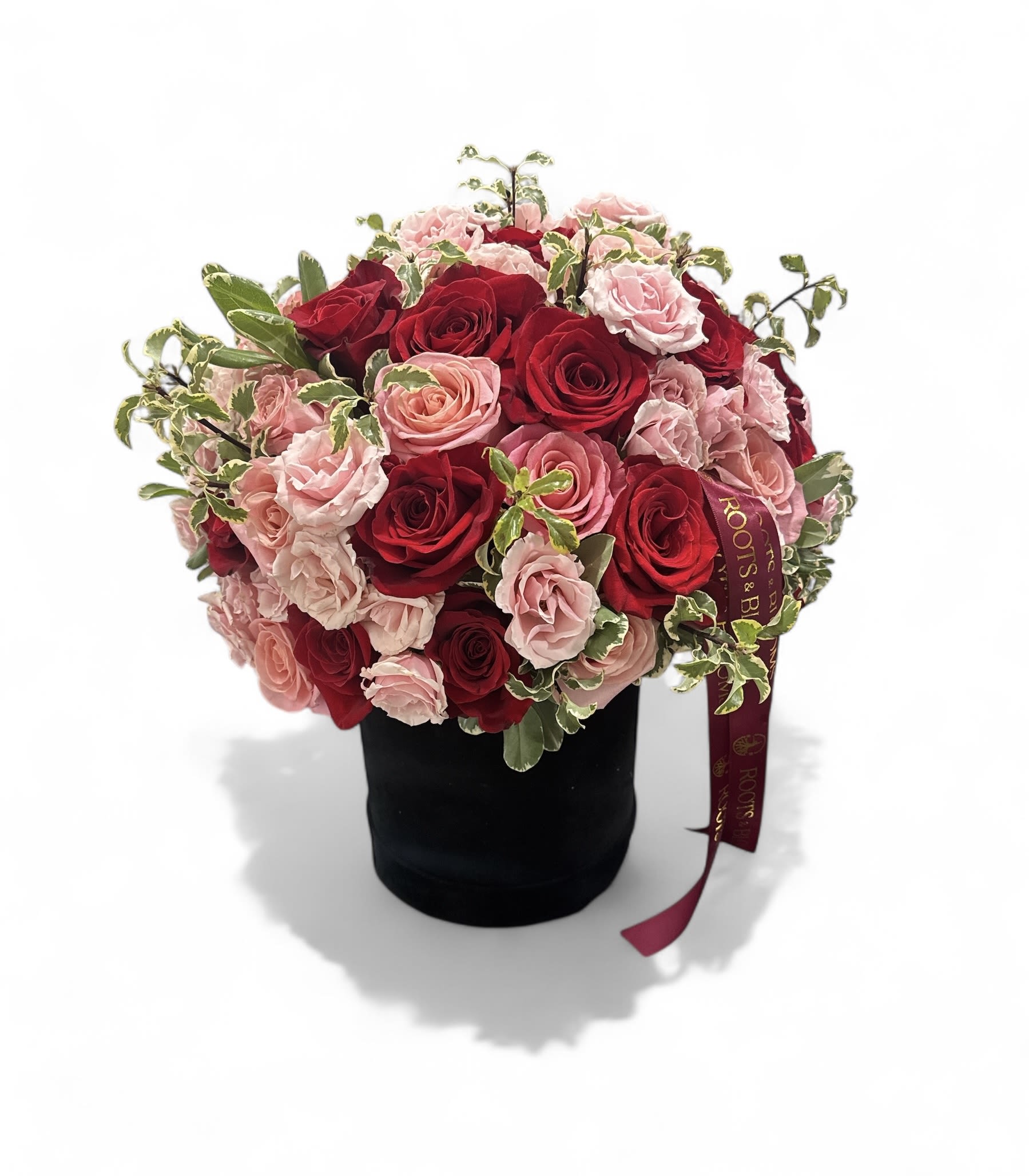 Bouquet of red and pink roses in a black hatbox