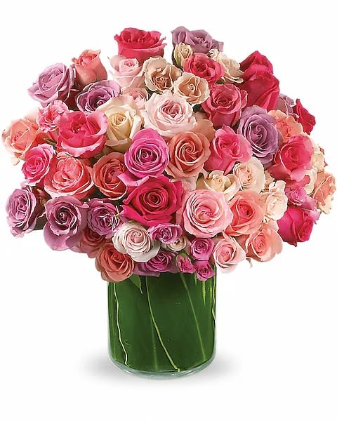 Rose Rapture - A lush dome of roses in pink, lavender, blush, cream and red makes this flower arrangement an unforgettable birthday bouquet, anniversary roses gift, or romantic gesture. The dense, tightly packed blooms create a soft yet lively color wash that reads both elegant and joyful-the kind of display that will make the person you're thinking of feel truly celebrated.  Each rose is layered into a full, rounded cluster and presented in a tall green glass vase that gives a bold contrast to the pastel petals and lifts the composition with height. The arrangement's compact silhouette and rich texture make it ideal for a dining table centerpiece or a bedside statement without overwhelming a room.  Perfect for marking birthdays, anniversaries, or simply saying "I'm thinking of you," this arrangement arrives ready to display; change the water every few days, recut stems at an angle, and place away from direct heat to extend bloom life.