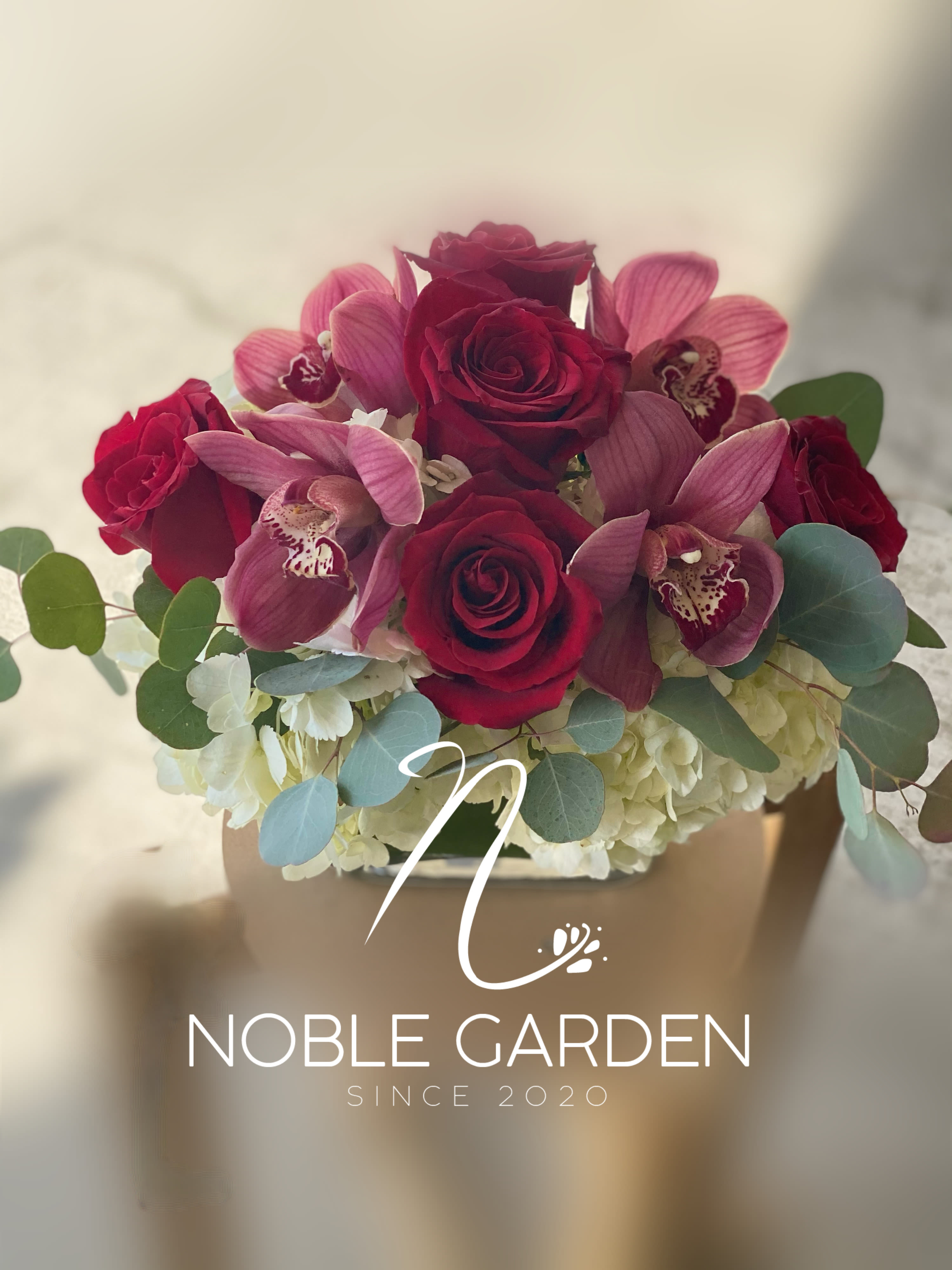 Bouquet of red roses and pink orchids with pale hydrangeas