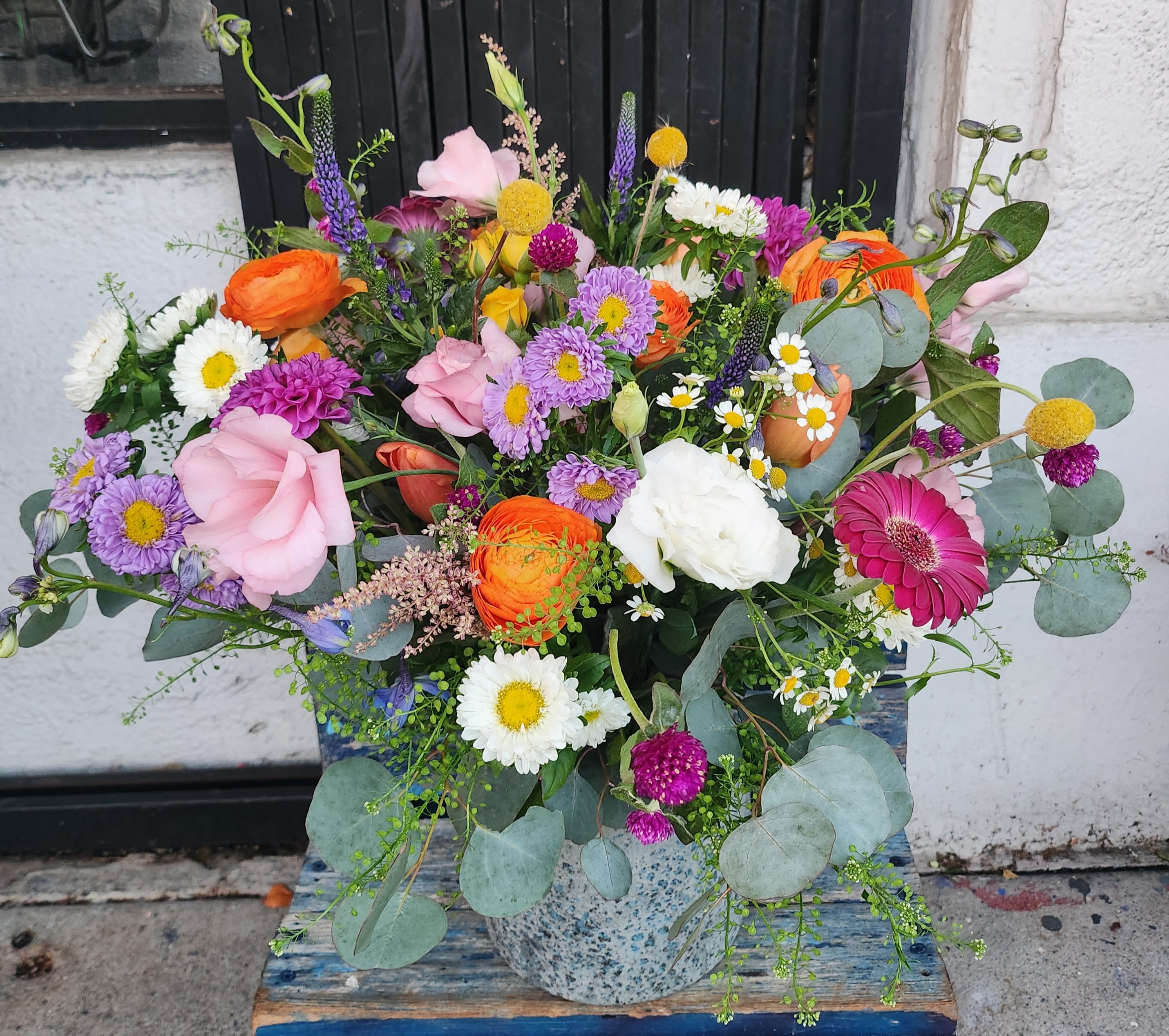 Colorful mixed bouquet in a speckled ceramic vase