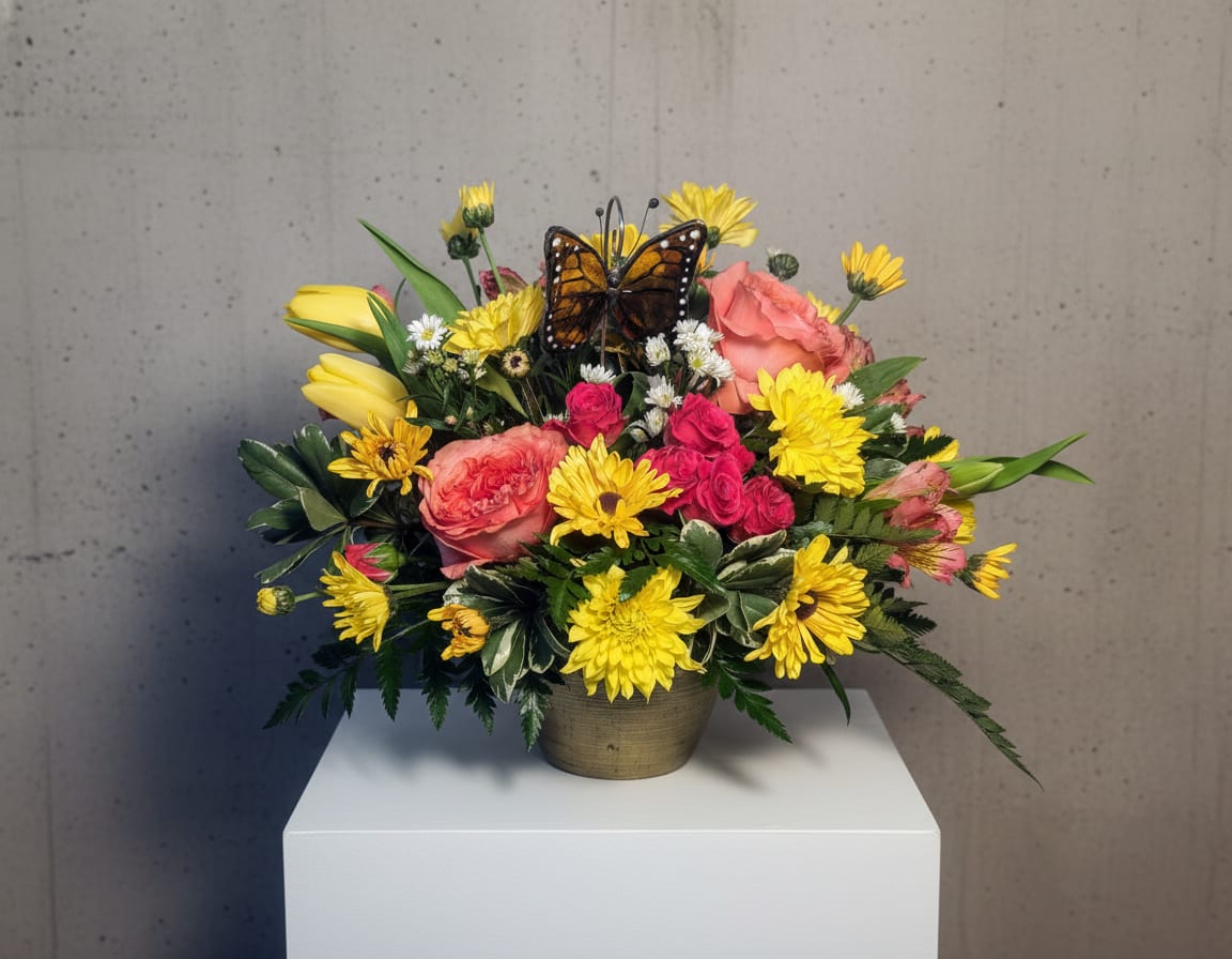 Bright mixed bouquet in a small vase with a butterfly accent