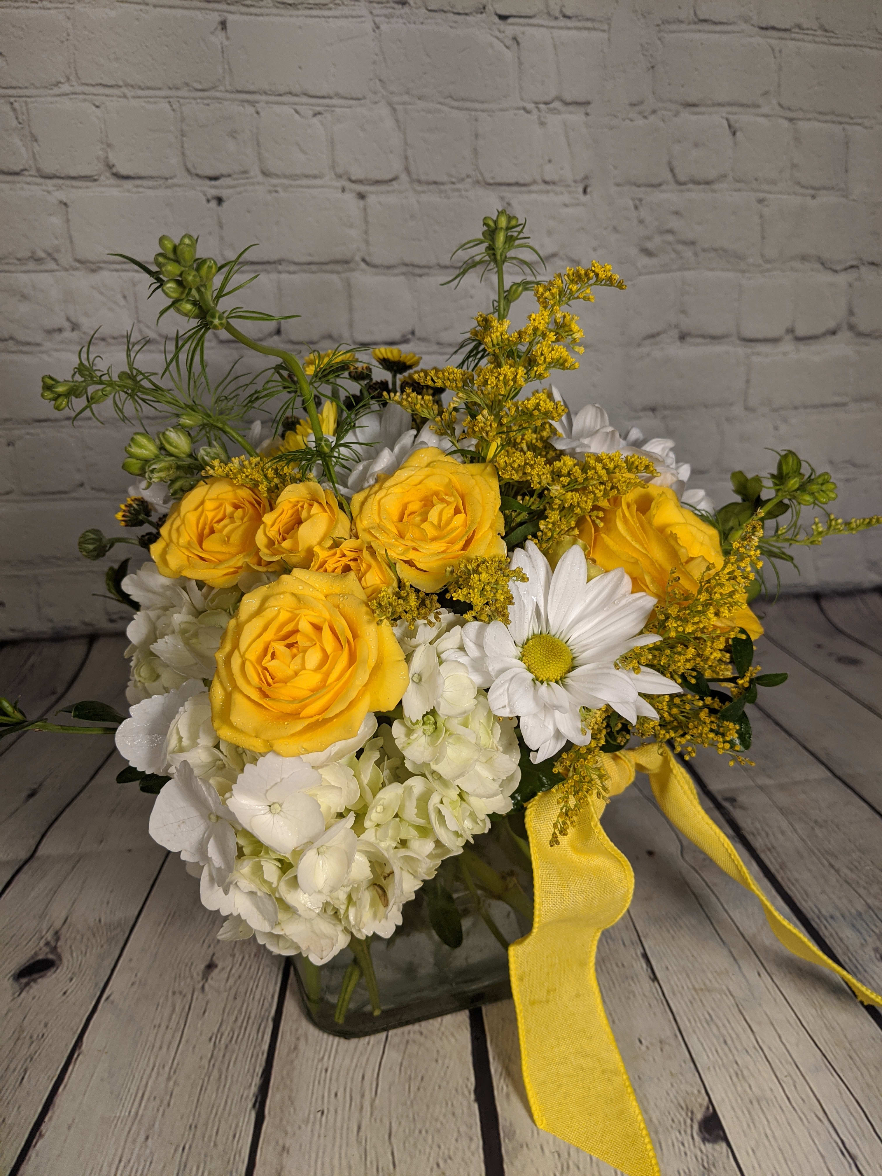 Sunny Daisy - Sunny Daisy is as bright and cheerful as they come. From its spectacular yellow roses to pure white daisies and alstroemeria, you're sure to send a smile when you choose these delightful daisies.
