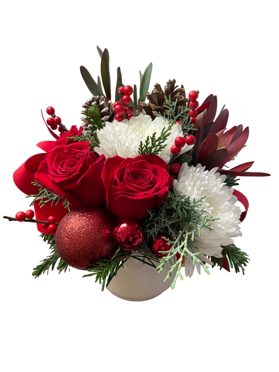 Red roses and white mums in a beige vase with pinecones and ornaments