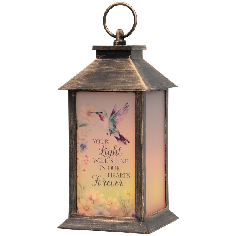 "Light Shine Forever" Lighted Sympathy Lantern - Lantern reads " Your Light Will Shine In Our Hearts Forever". Beautiful lantern for sympathy.  These lanterns are made of weather friendly materials and UV printed frosted glass. They include a flameless LED candle with a built-in automatic timer: 6hrs ON/18hrs OFF (3 AAA batteries are included). They are suitable for hanging or free-standing use. Matching bow is added for presentation.   W: 5.5" H: 13" D: 5.5"
