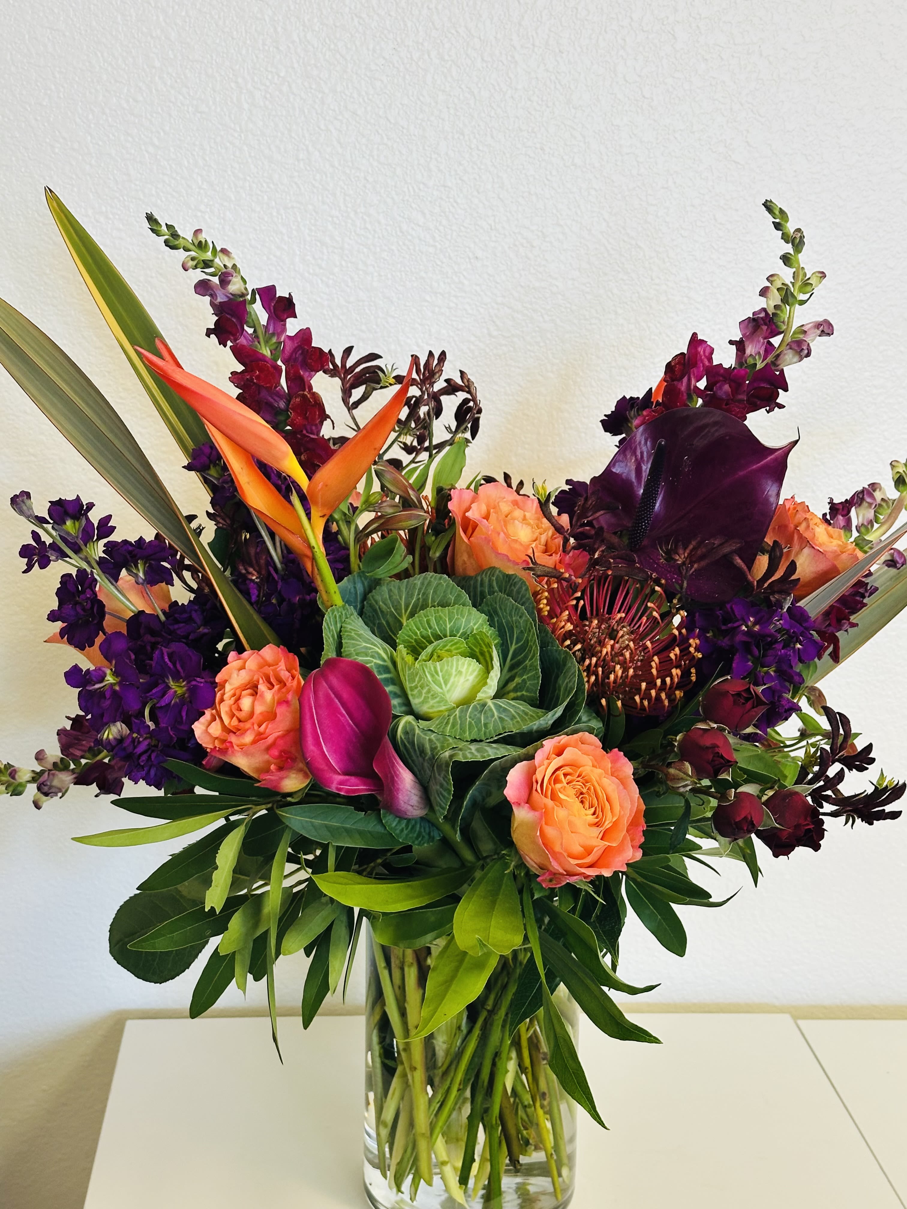 Vision of Beauty - Head to the tropics with this spectacular and exotic display of parakeet heliconia, snapdragons, kale and more, artfully arranged in a tall arrangement that will transform any room into an island paradise.
