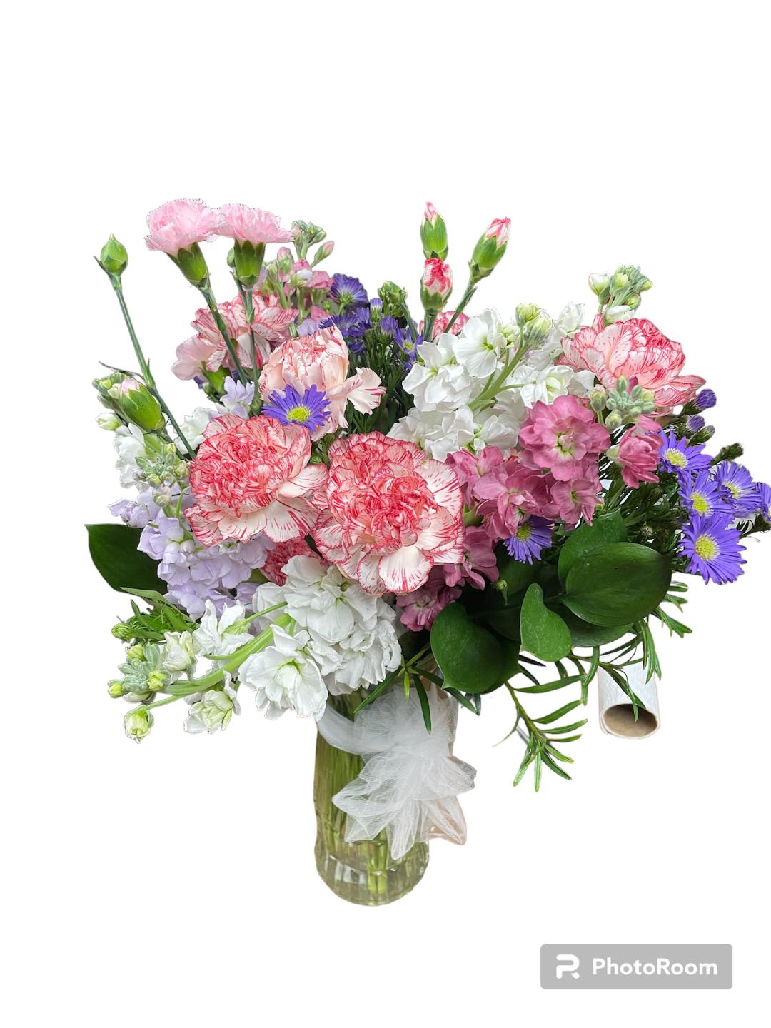 Mixed bouquet of pink, white, and purple flowers in a glass vase