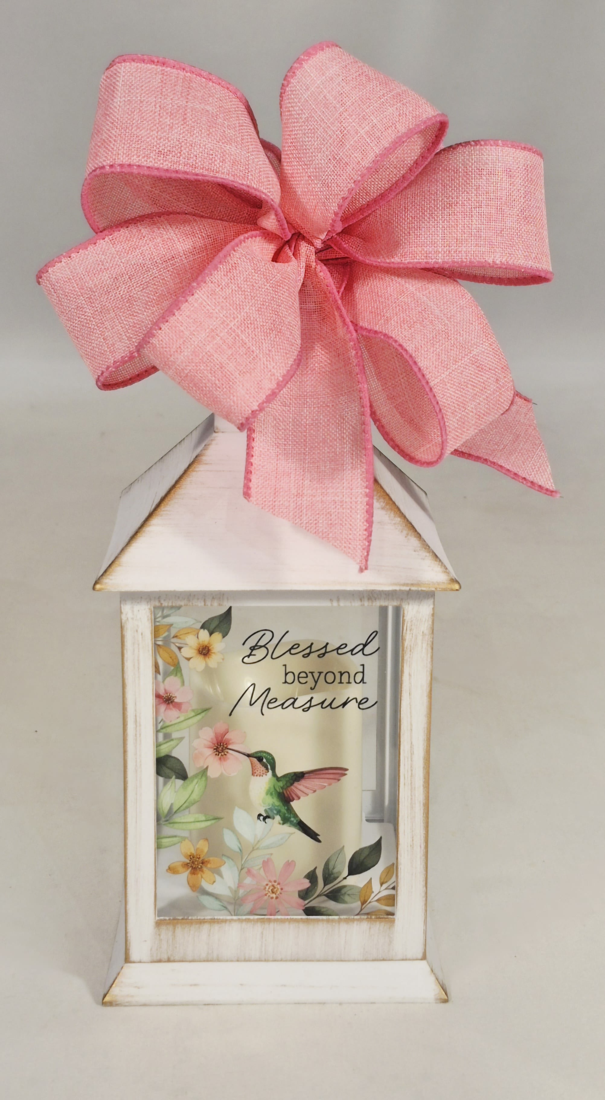 Decorative lantern with a pink bow and floral hummingbird print