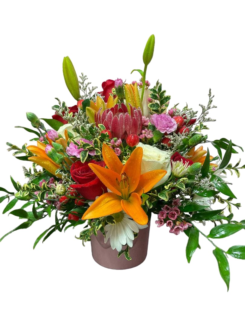 Mixed bouquet with lilies, roses, and pink accents in a vase