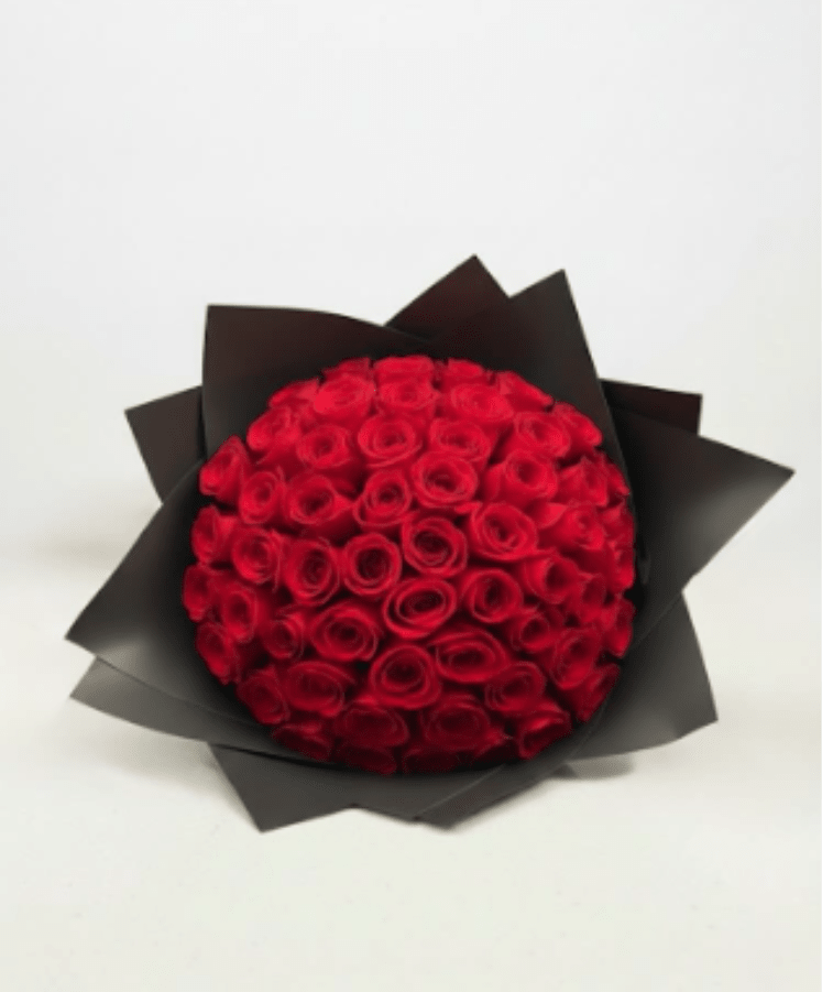 Round bouquet of red roses wrapped in black paper