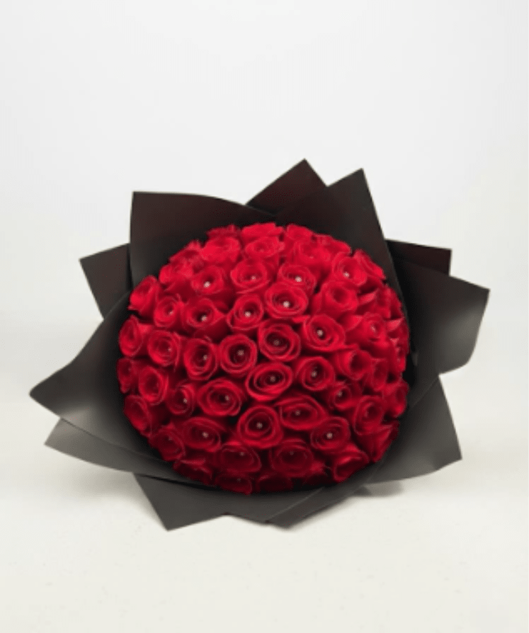 Round bouquet of red roses wrapped in black paper