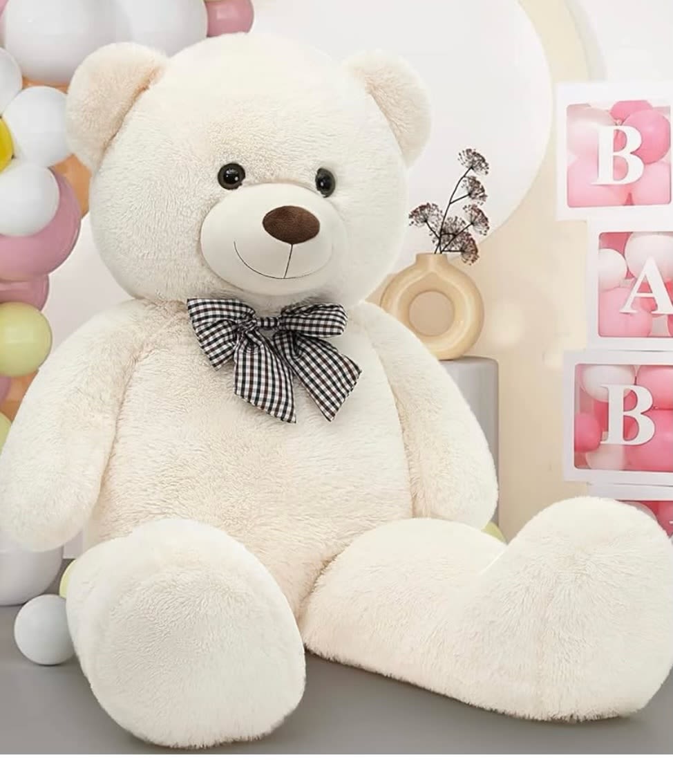 Large white teddy bear with a black checkered bow, surrounded by pastel balloons