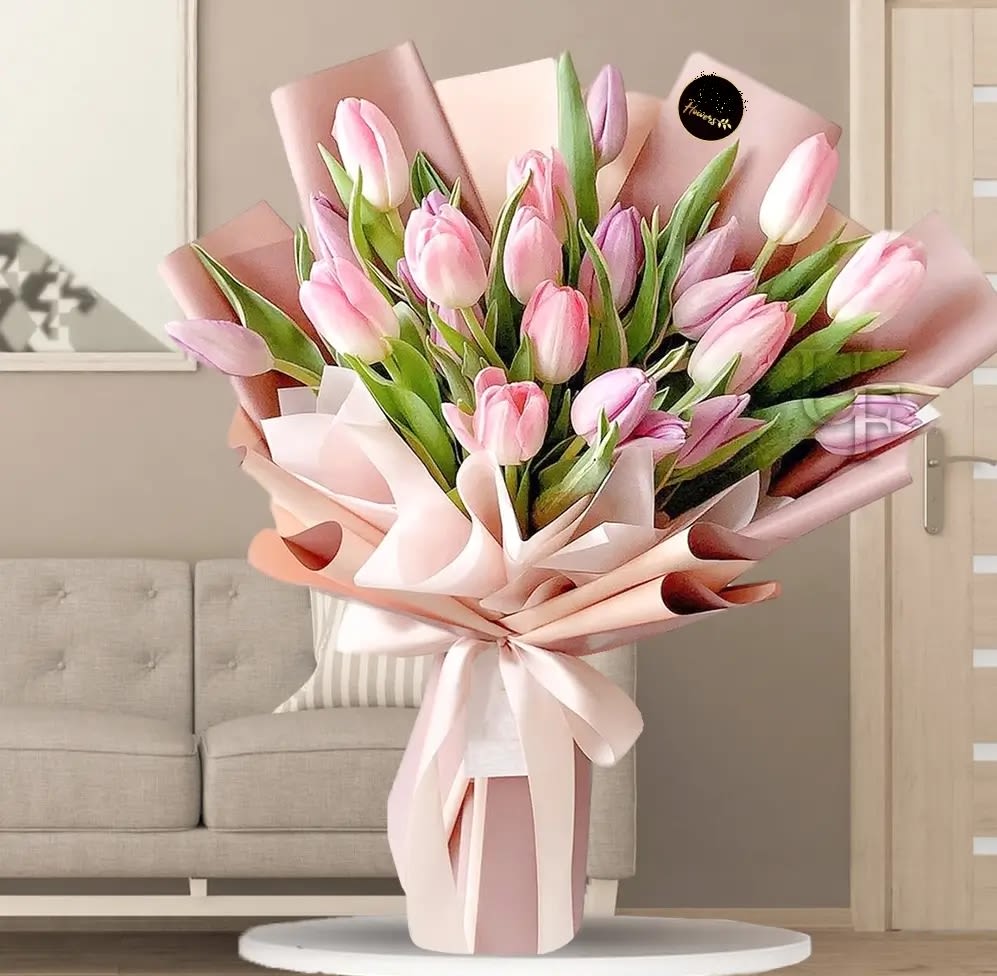 Pink tulip bouquet wrapped in pale pink paper with a ribbon