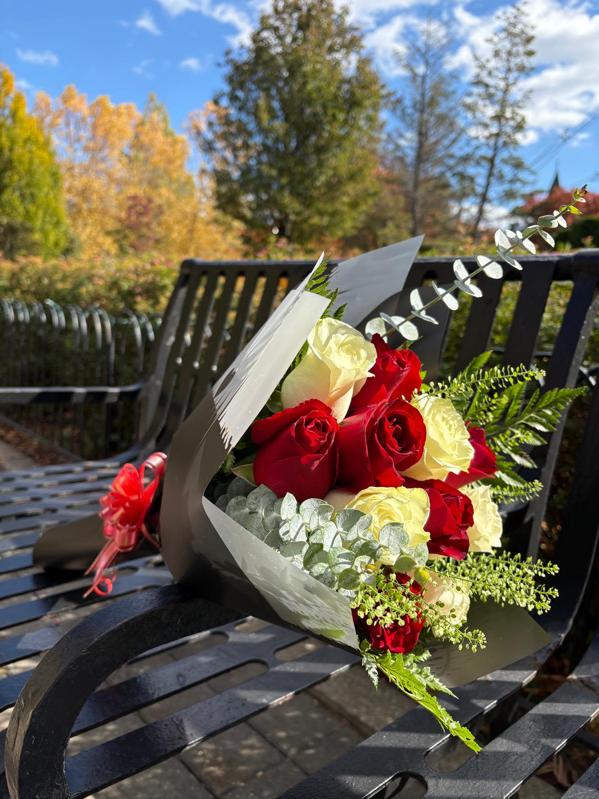 Bouquet of red and white roses wrapped in black paper