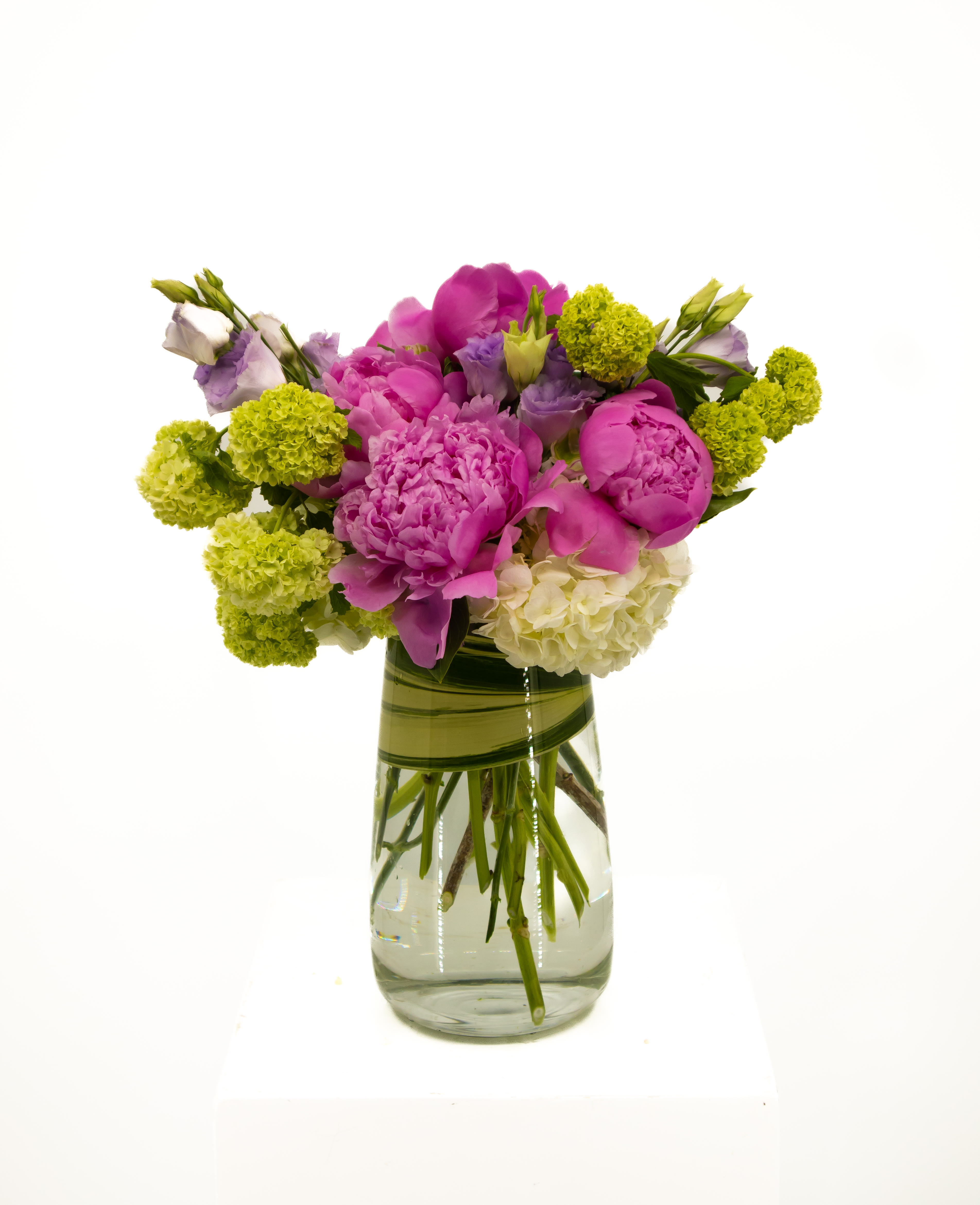 Ruth - A stunning tall arrangement that captivates the eye. Loaded with peonies, hydrangea, and other seasonal flowers. This arrangement will sue bring joy to anyone who receives. It’s perfect for all occasions.   *Peony color subject to availability 