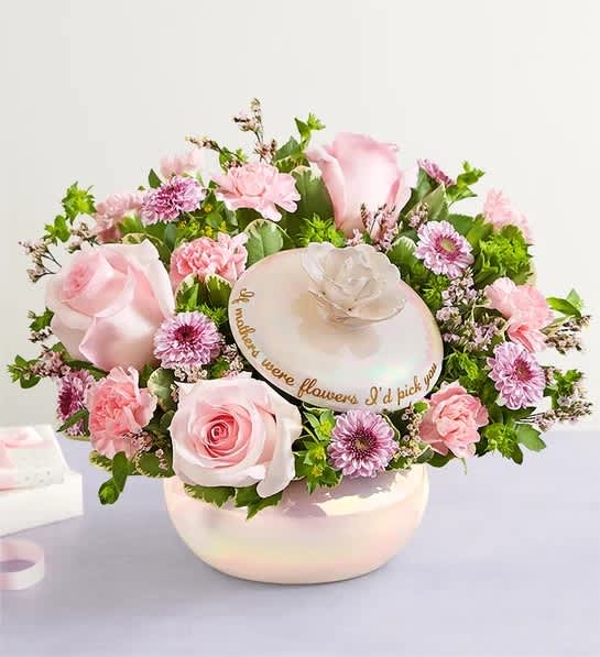 Pink roses and daisies arranged in a round hatbox with a decorative lid