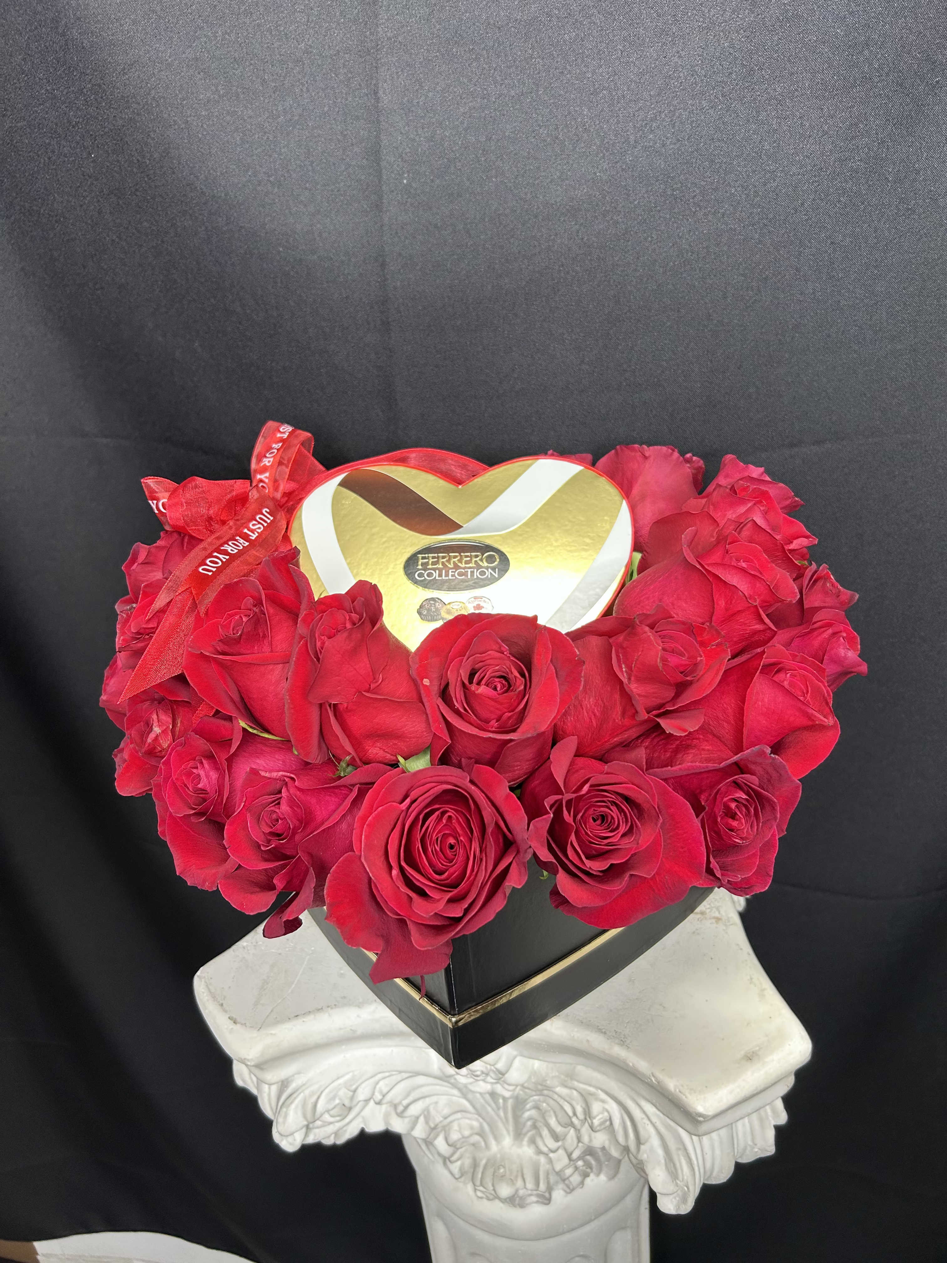 Heart-shaped box of red roses with a Ferrero Collection chocolate box on top