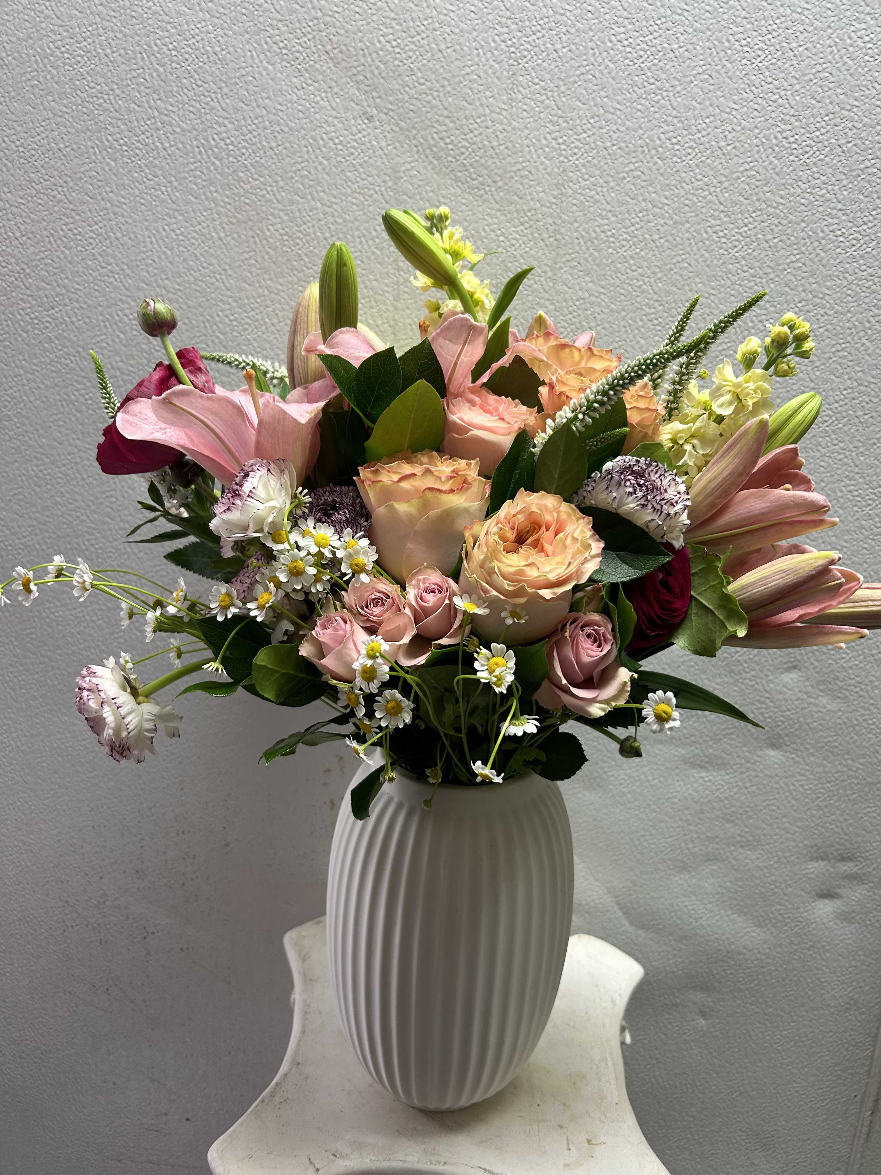 Mixed pink and peach bouquet in a white vase